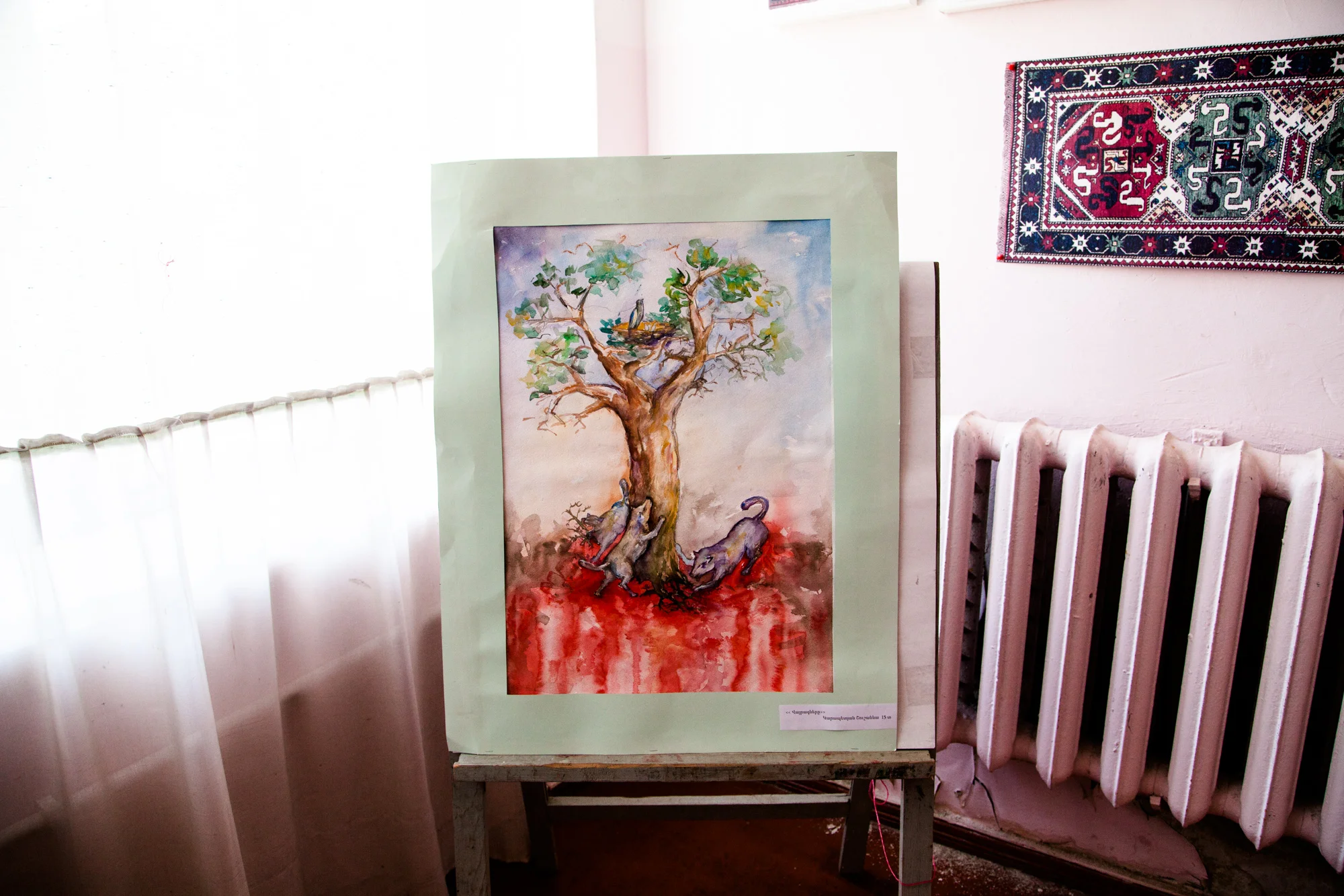 À la Maison de la Culture, où l'on trouve bibliothèque et ateliers de dessin et broderie, Shushan a gagné le Premier Prix du Concours d'aquarelle. Elle a 13 ans, et son dessin figure le génocide arménien. " Je m'appelle Shushan. Dans mon dessin, j'ai décrit... (Elle se reprend.) J'ai dédié mon dessin au génocide. J'ai peint un arbre qui représente l'Arménie, ses racines sont profondes dans la terre. Et les carnassiers représentent les Turcs, qui veulent déraciner l'arbre. Mais ils ont beau essayer encore et encore, ils n'arrivent pas, jamais, à le déraciner totalement. Les carnassiers sont les Turcs. Là, c'est le sang des victimes innocentes. Et les Arméniens ont installé sur l'arbre leur nid paisible, leur berceau. " Extraits du webdocumentaire Ashotsk, aux confins de l'Arménie .