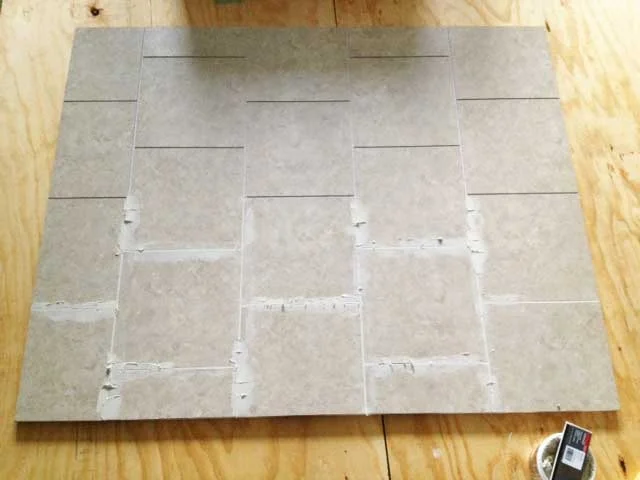 A lot of the new vinyl tile is groutable which helps it do a pretty convincing job of impersonating stone and ceramic tiles. This was the start of filling grout into all the seams.