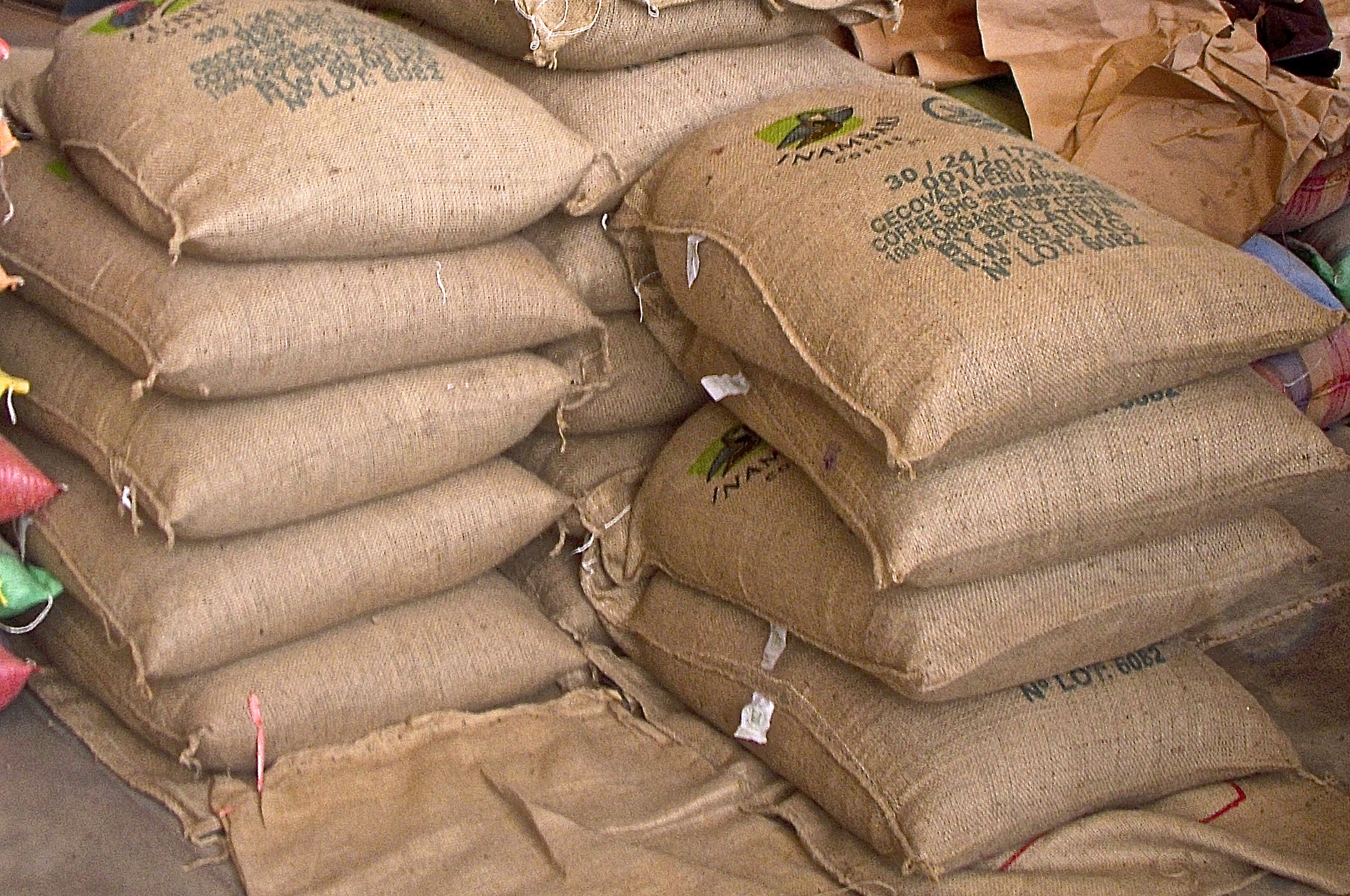 16 huge bags (151 pounds each!) of coffee in a Lima warehouse.