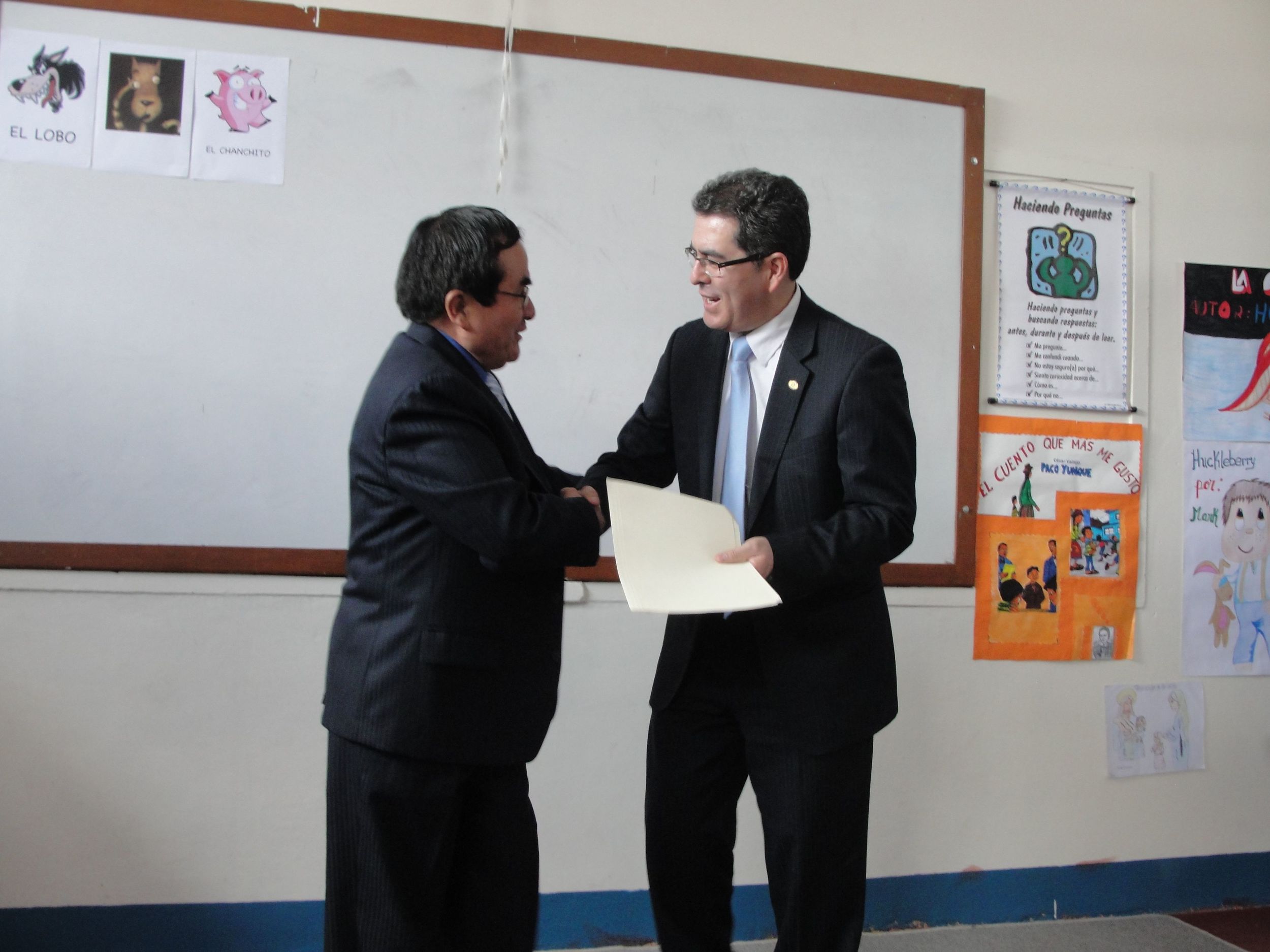 The minister of education handing over the signed papers to Alfredo, CUDA executive director