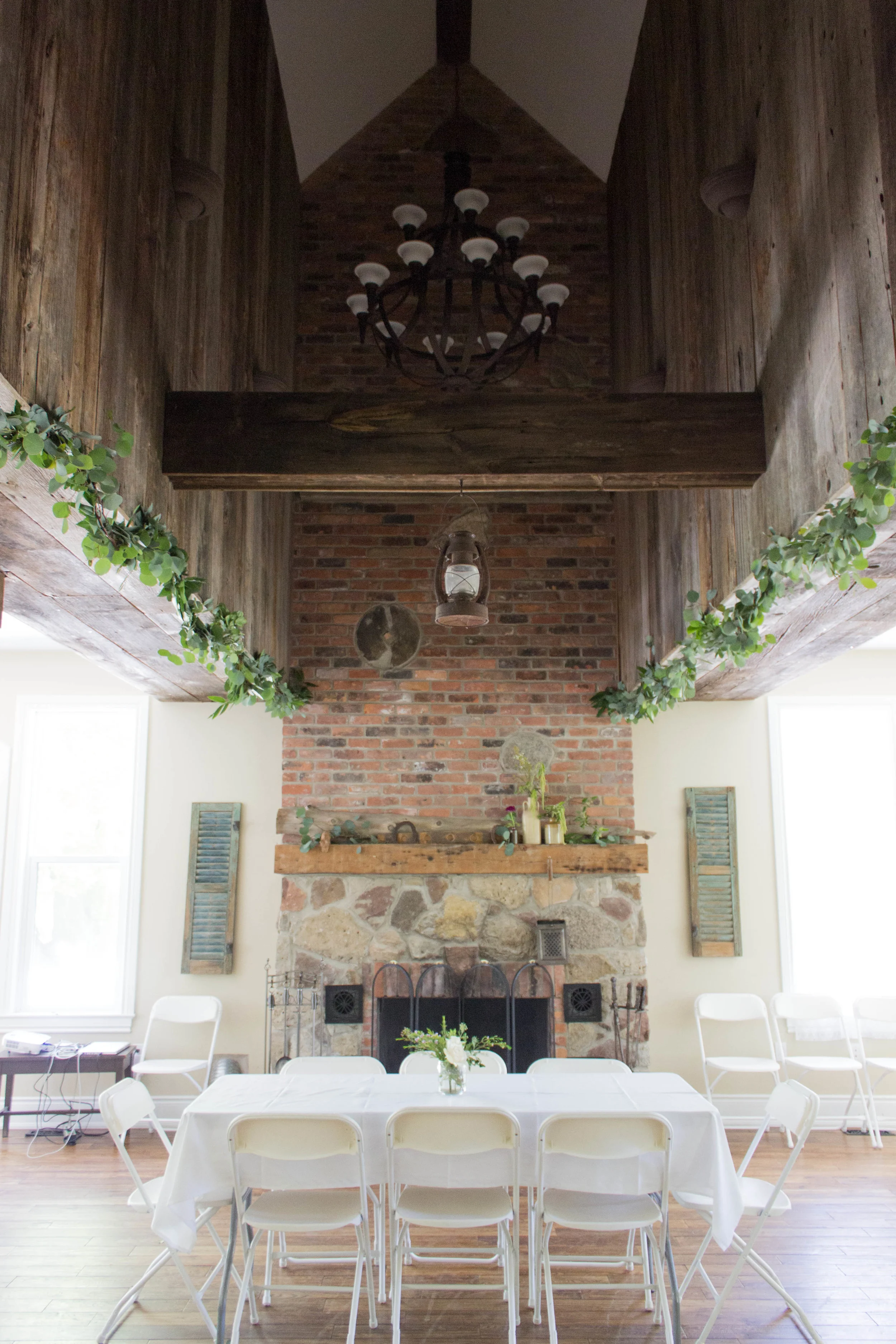 The Great Room, a later addition to the farmhouse, had a fantastic raised section of roof! Garland hung from the old barn wood, with greens and various blooms were placed on the mantle!