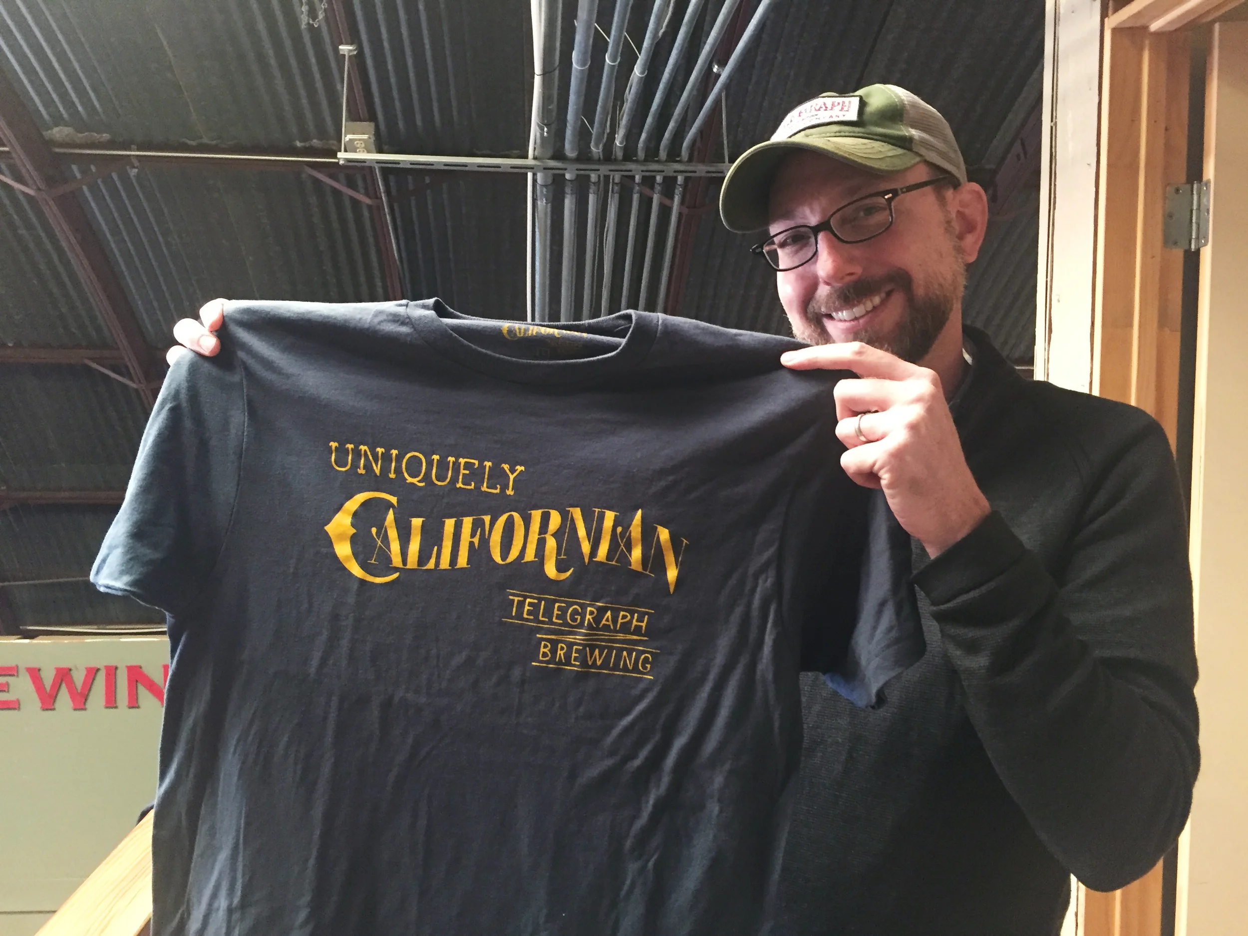 Brian Thompson, owner of Telegraph, holding the new shirt.