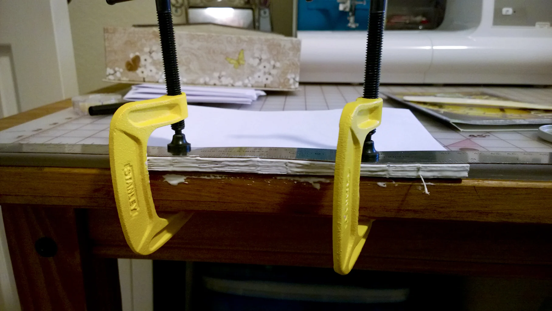 glueing the signatures after being sewn, using c-clamps to keep the pages together