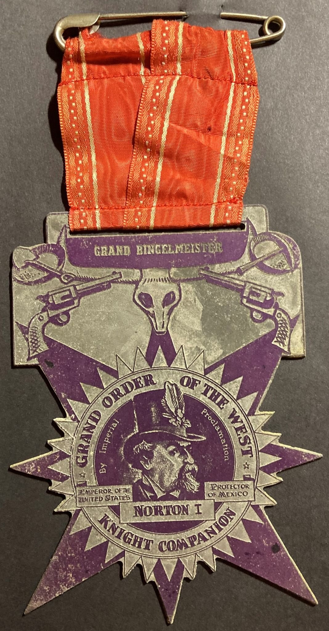   Grand Order of the West medal, unknown date.  7 1/2” long (including ribbon), 3 3/4” wide. Secondary texts: “Knight Companion” and “Grand Bingelheimer.” Norton artwork the same as for  this promotional souvenir  produced by the  San Francisco Chron