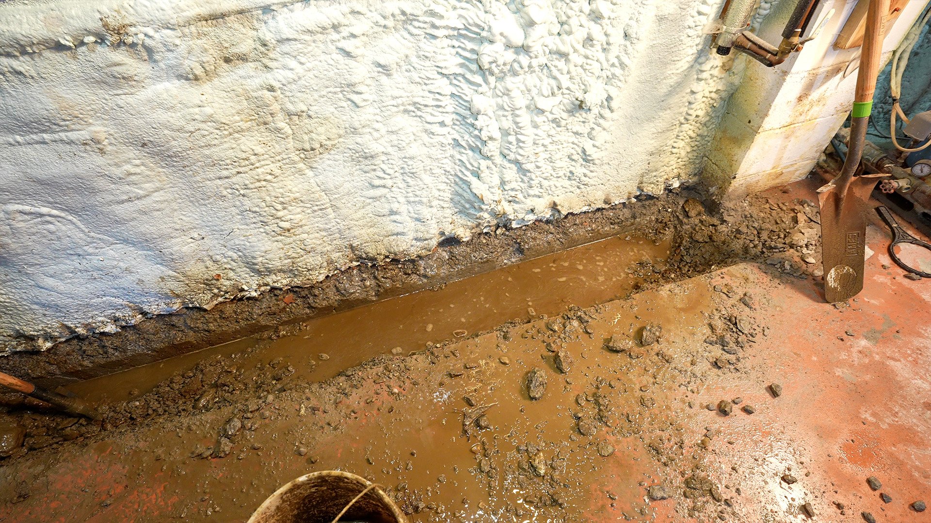 water collecting in a trench next to foundation