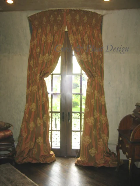 These panels cover an eyebrow arched alcove and go back about 18" to the door creating almost a tent like effect. There is 12" of smocking at the top and are held back by faux Italian stringing. Designer: Jeannie Carpenter; Workroom: Cord & Pleat Design.