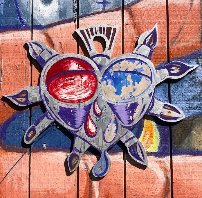 Balmy Alley - Heart Milagro with paint and paintbrushes a.k.a “balmilagro” is part of a mural by Jamie Morgan called “Tribute to Archbishop Oscar Romero” (2001)