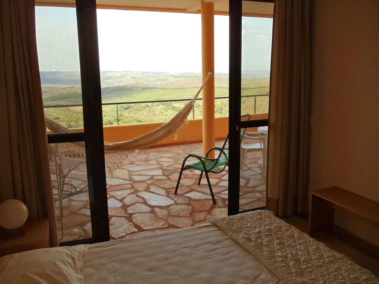 From the bedroom of Alegria, across the spacious, covered private veranda/lanai, opening up to the endless lush green rolling hills surrounding Abadiania.