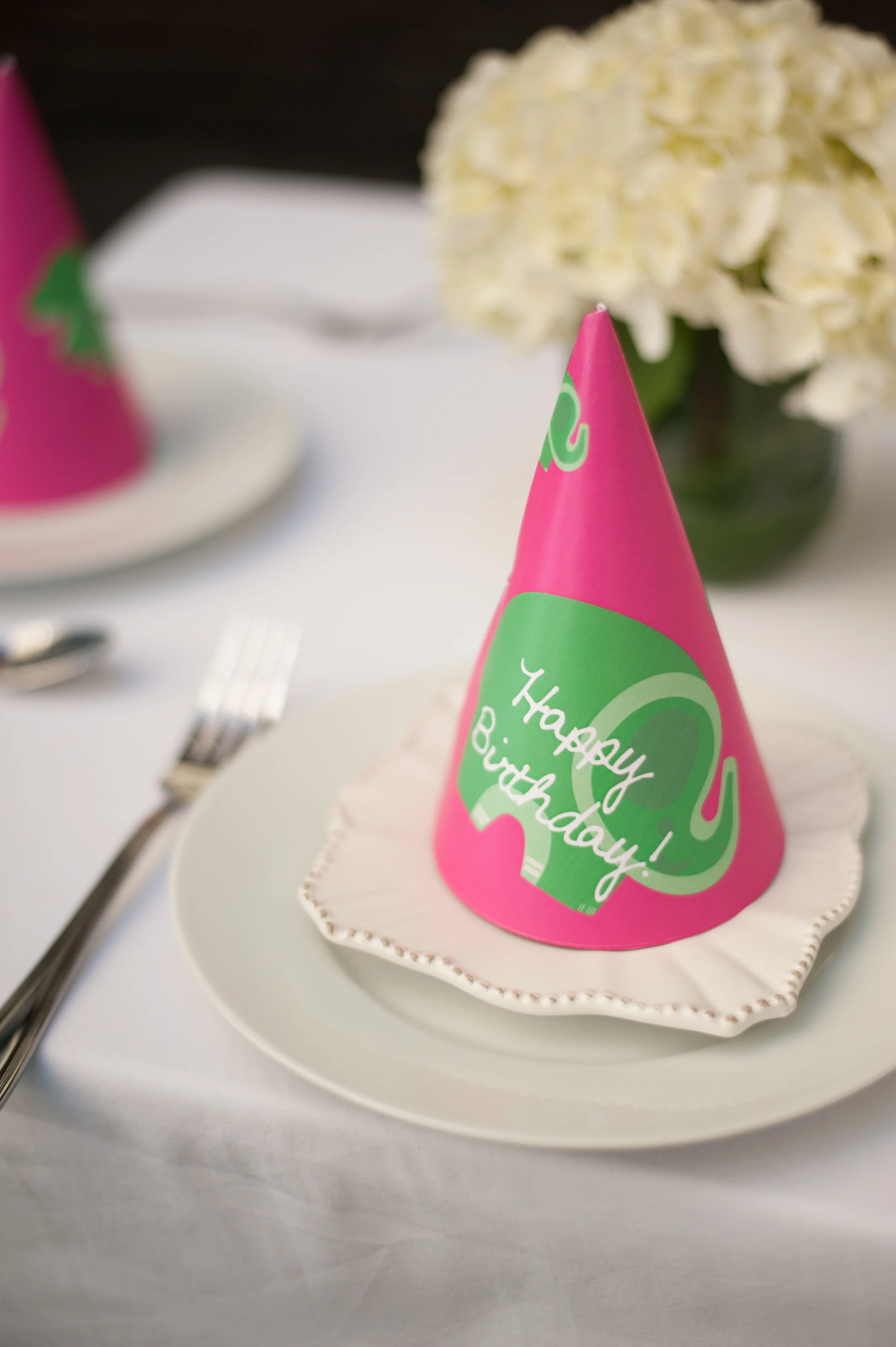 Context // I wanted a way to bring a little celebratory whimsy to this project. A party hat seemed perfect. Concept // This party hat utilizes the original typeface from the invitation as well as the elephant. In order to create a bit more whimsy, I put the elephant and type on at an angle. *Photo by Liga Photography, Staging by KalinKalin