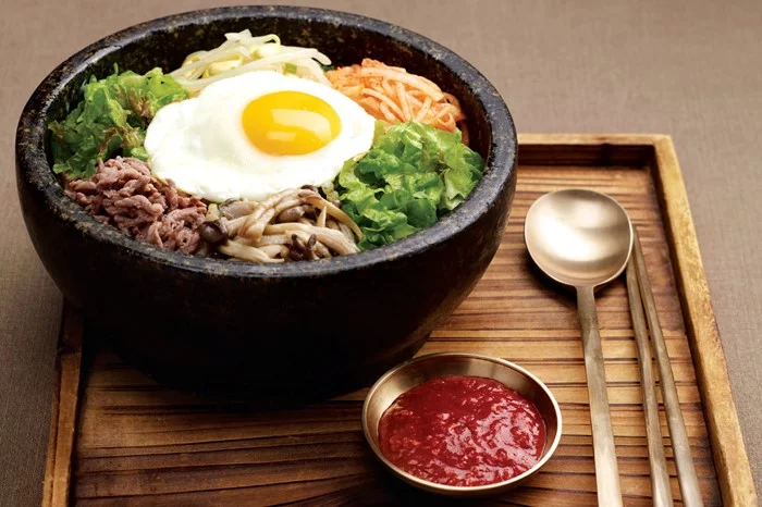 Bibimbap - Cooked rice served with fresh and seasoned vegetables, minced beef and chili paste.