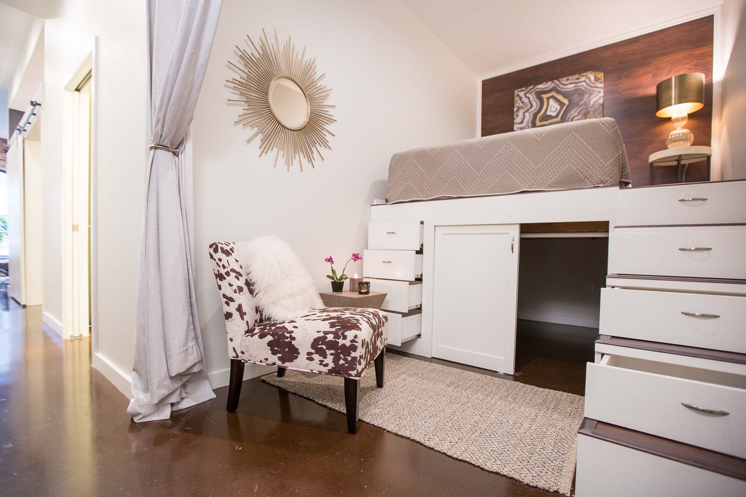 The investor/clients had the great idea to add a lofted guest room with wood paneled headboard wall and plenty of storage. They implemented and we added the cowhide chair and detailing. 