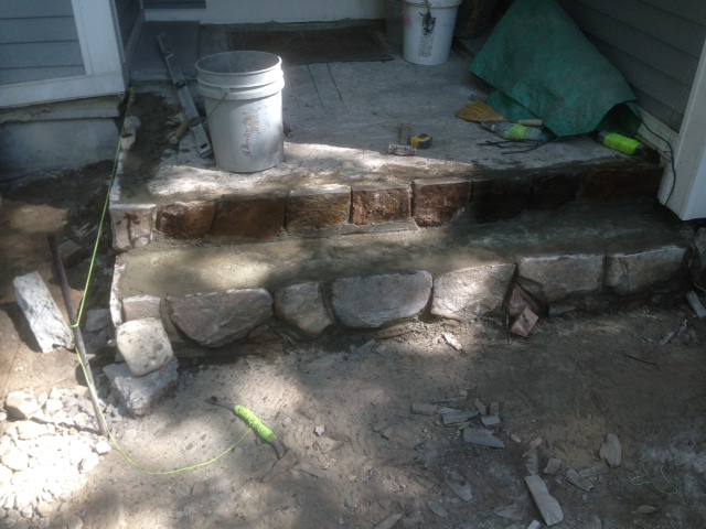 Hand cut fieldstone rise is installed.