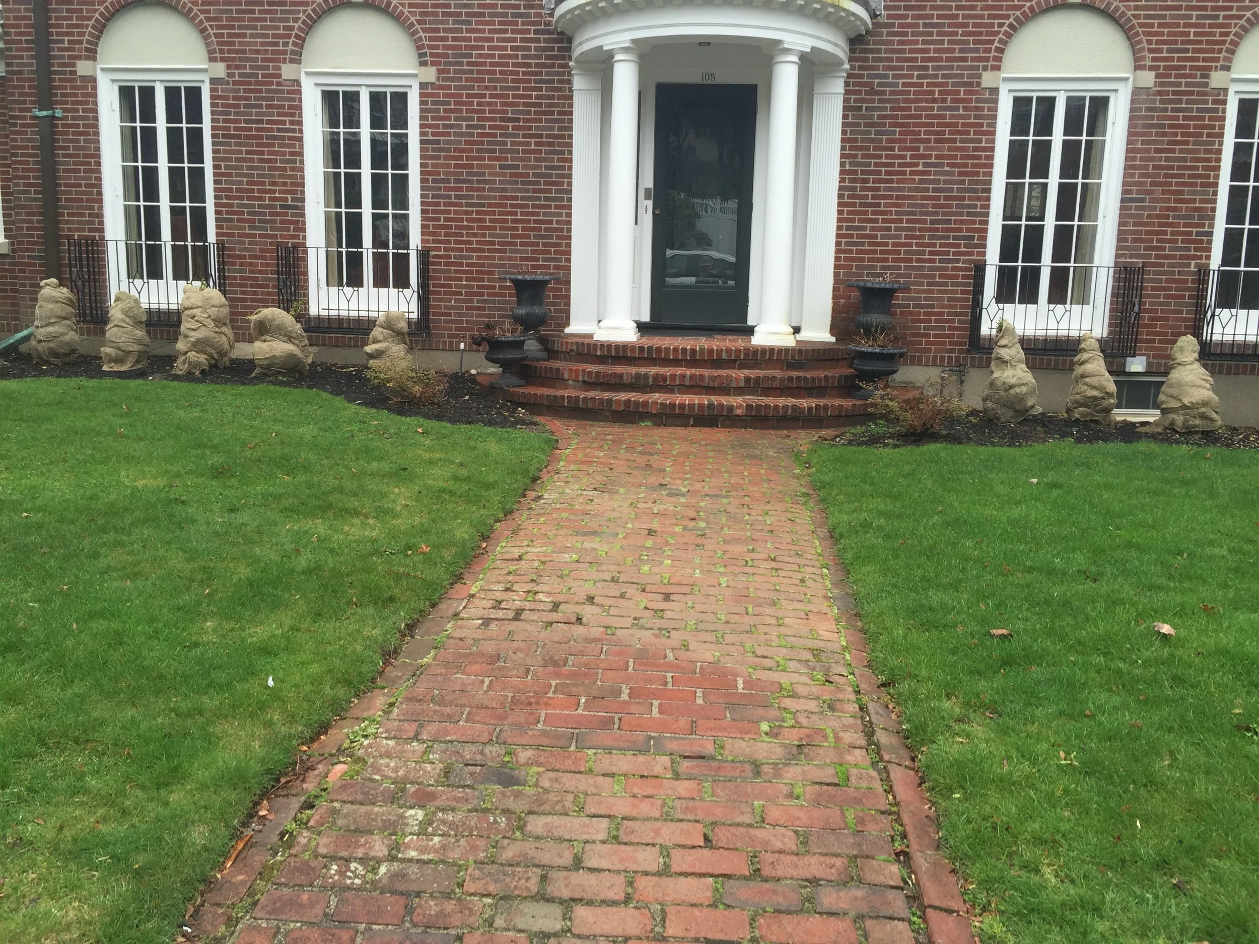  This stately Brookline home needed a makeover. The owner's wishlist included a new driveway and natural walls, an updated front walk, repointing of the brick on the existing front stoop and a new landscaping plan for the front gardens.  But, it was 