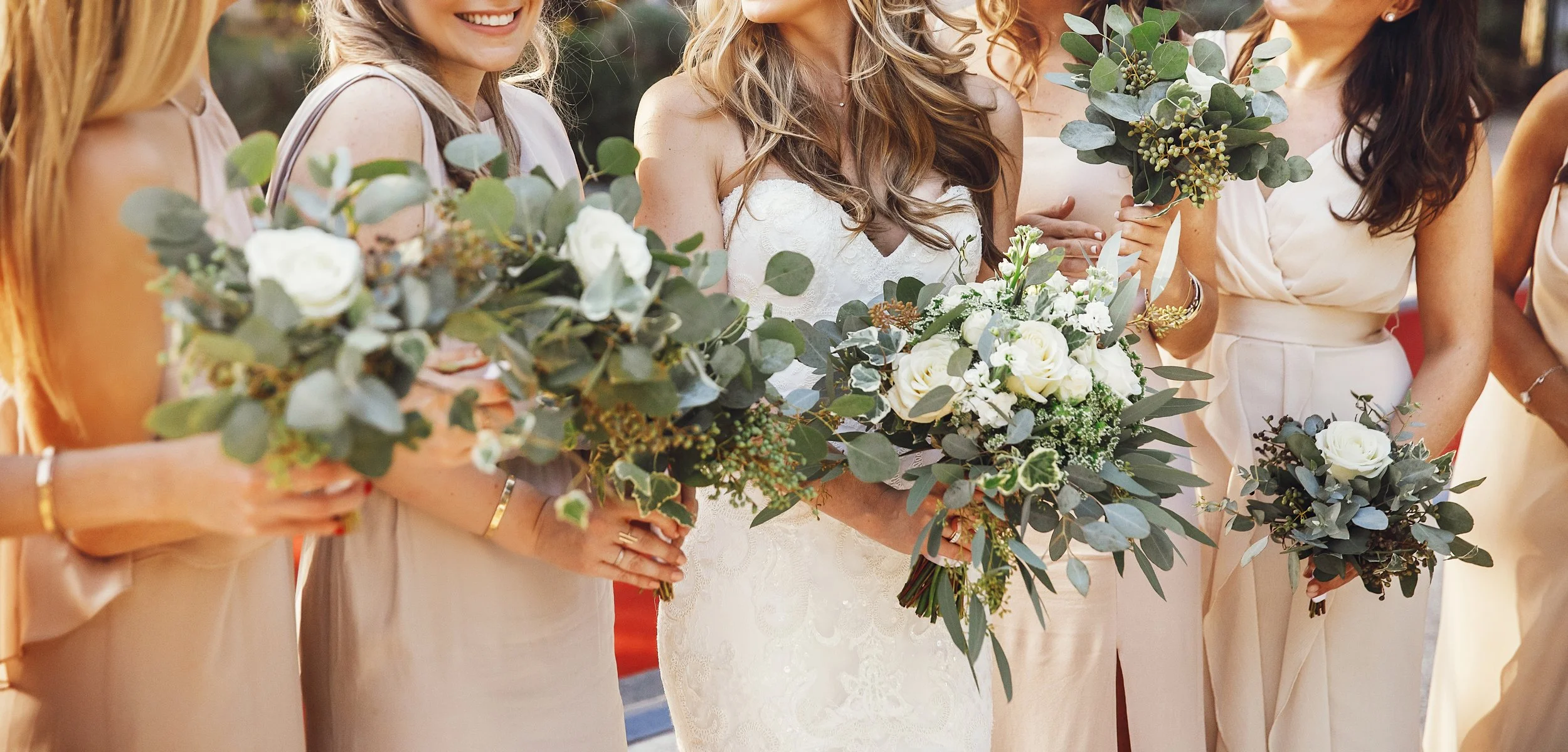 bride-bridesmaids-with-pastel-bouquets-stand-side-by-side.jpg