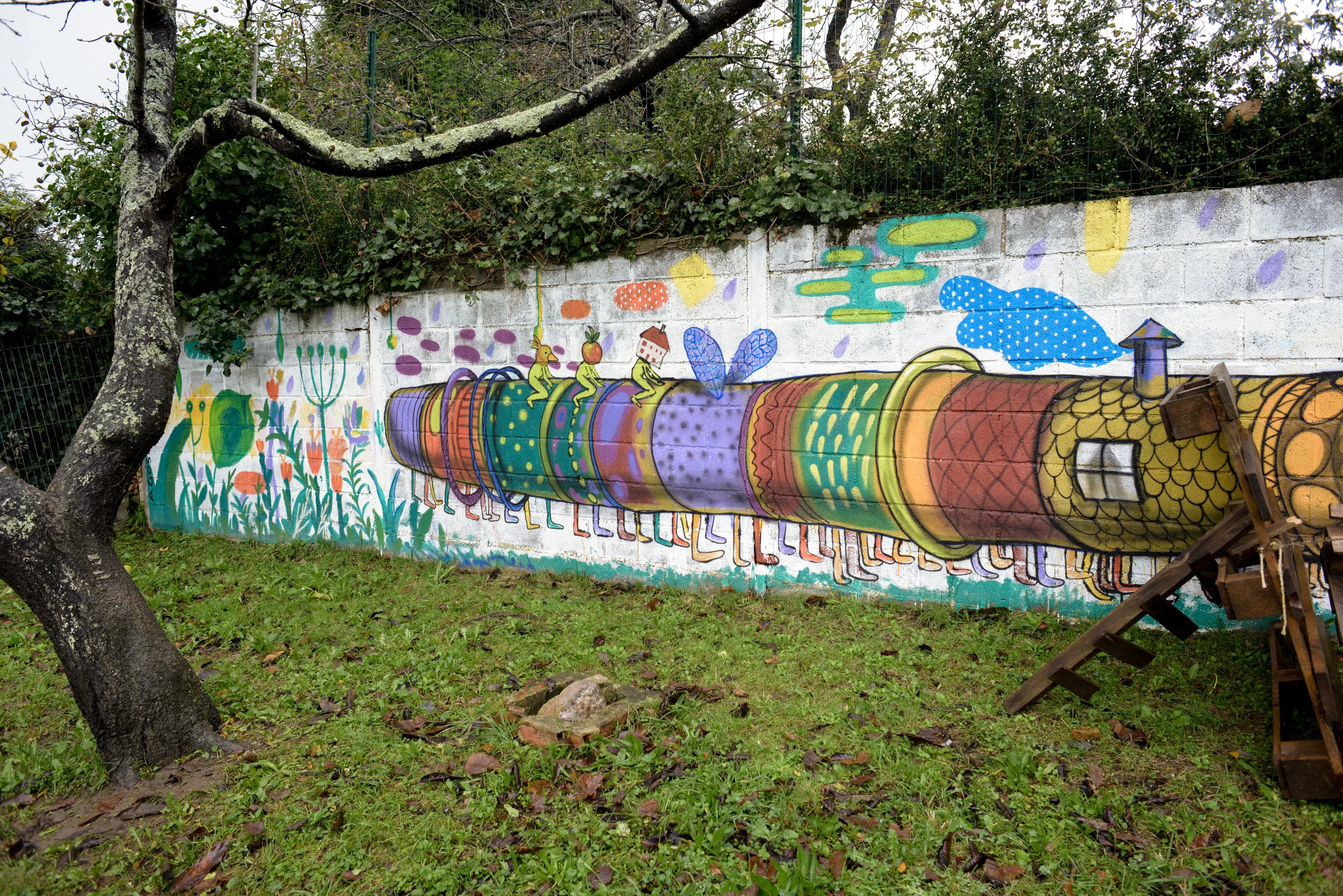 Un enorme graffiti multicolor alegra la vista de un muro de bloques en el patio de Andolina.