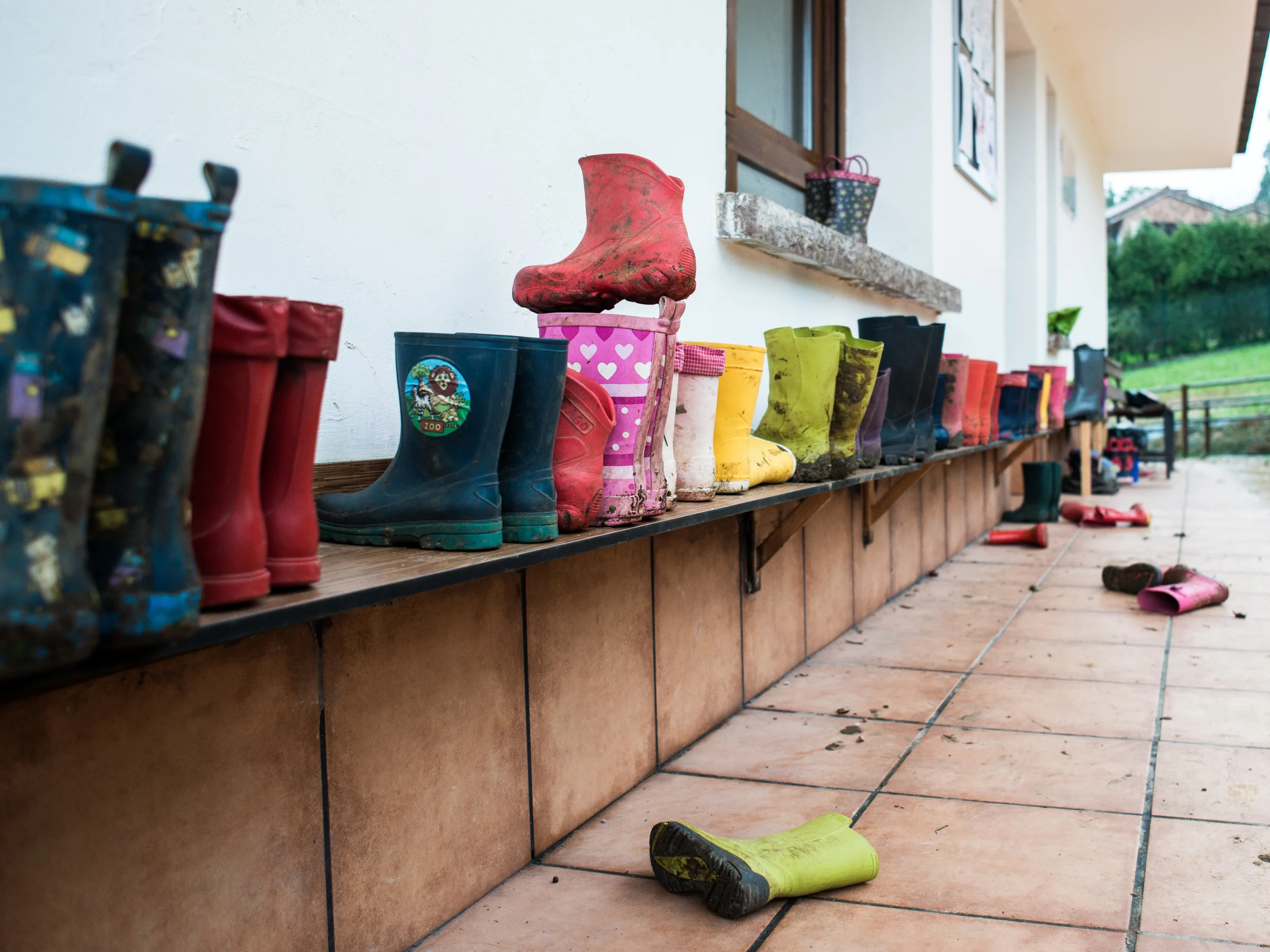 Las botas de agua a la entrada de Andolina, dispuestas en una estantería.