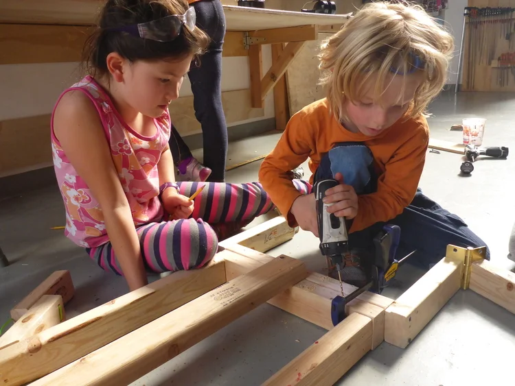 Una niña y un niño taladrando madera en Tinkering School , San Francisco (Estados Unidos)