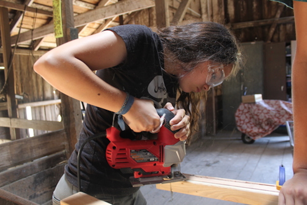Una joven cortando madera con una caladora, Tinkering School , San Francisco (EEUU)