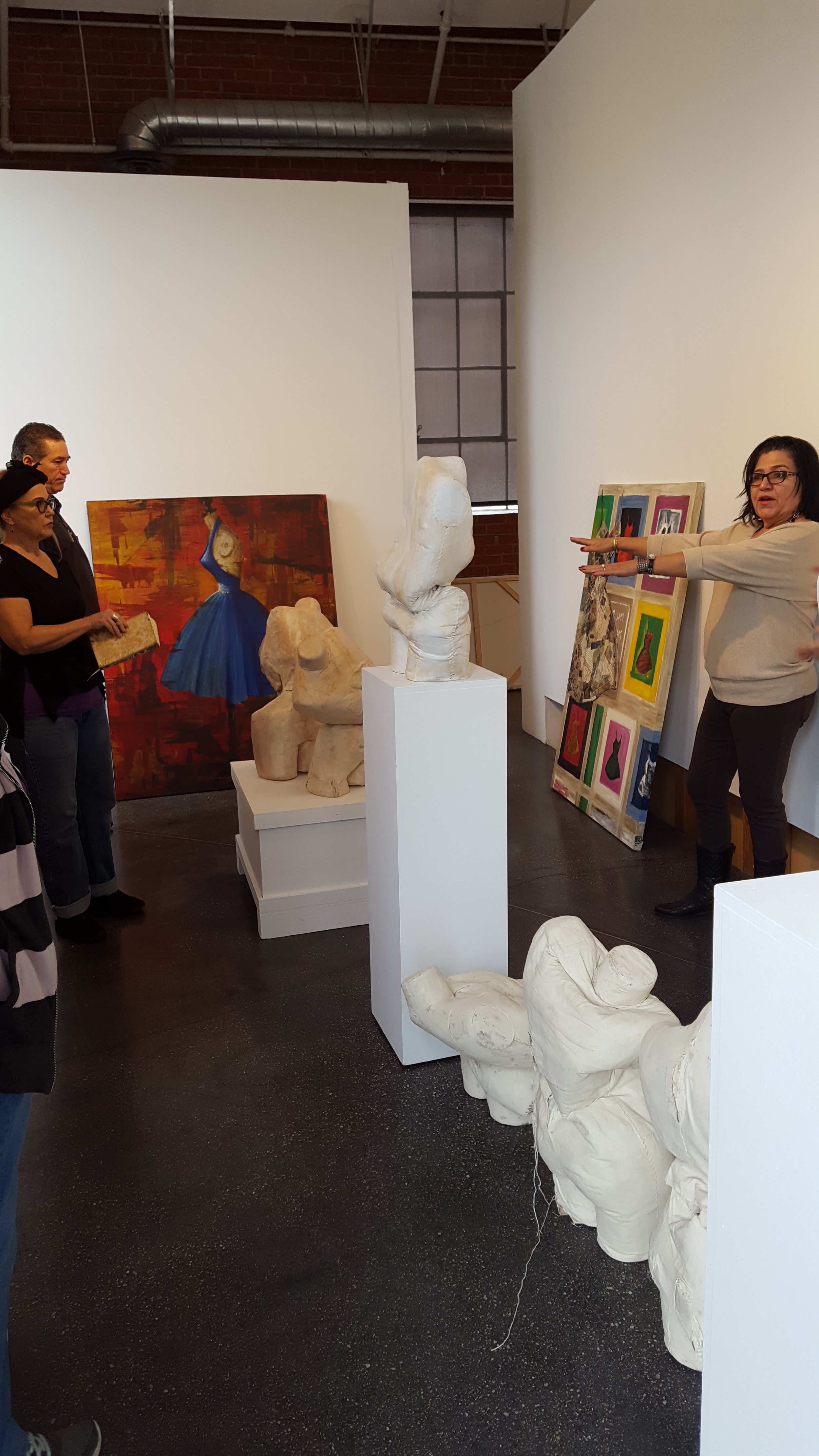 Curator Linda Vallejo (right) giving critique and instructing us where to put what. Artwork by Dawn Marie Forsyth (left with book). | Photo credit: C. Rasmussen. 