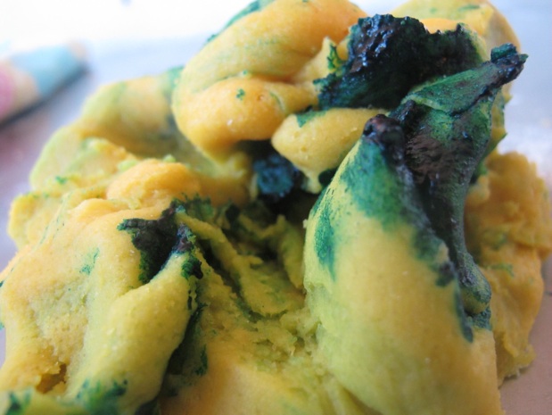 Mixing blue food coloring into yellow play dough