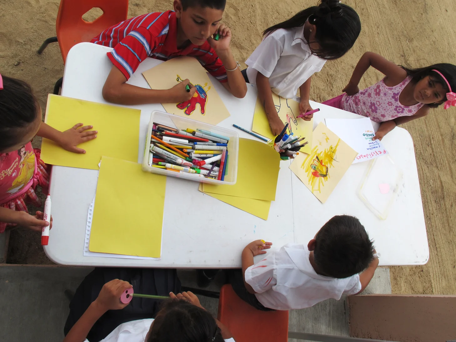 The kids draw while they wait for the graduation ceremony to start.