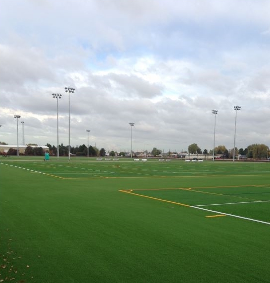 AURORA SPORTS PARK - The expansion project consisted of furnishing and installing four (4) multi-sport synthetic turf fields, concrete seat wall surrounding fields, a low site wall with perimeter 30’ tall safety fencing, concessions area, fully plumbed and heated restroom building, field identification on a scaffolding structure, 372 parking spaces, field lighting, parking, lot lighting, pedestrian walkways, natural turf practice area and landscaping.