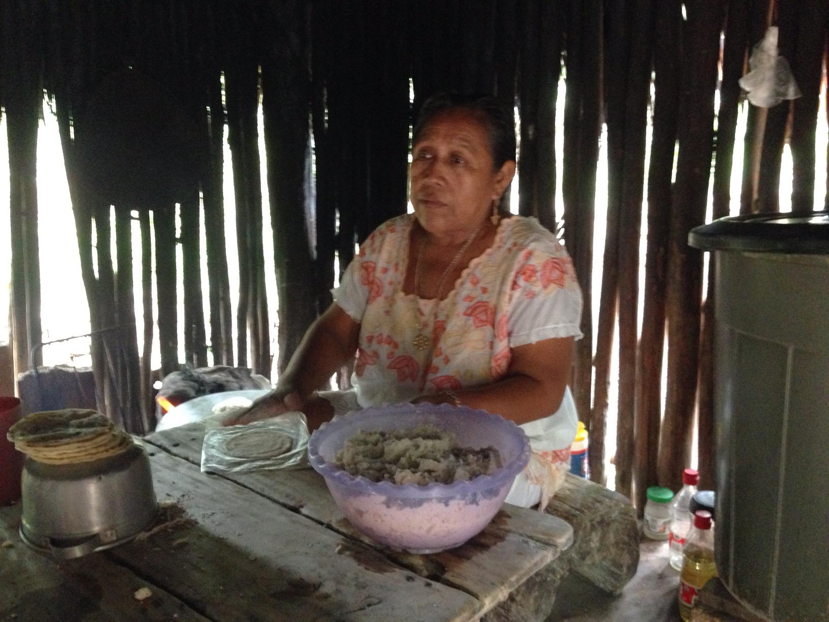 Francisca works in her kitchen to make tortillas from the ground corn meal. She cooks them on a very hot stone (on the ground just to her right) turning them with her fingers! Ouch!