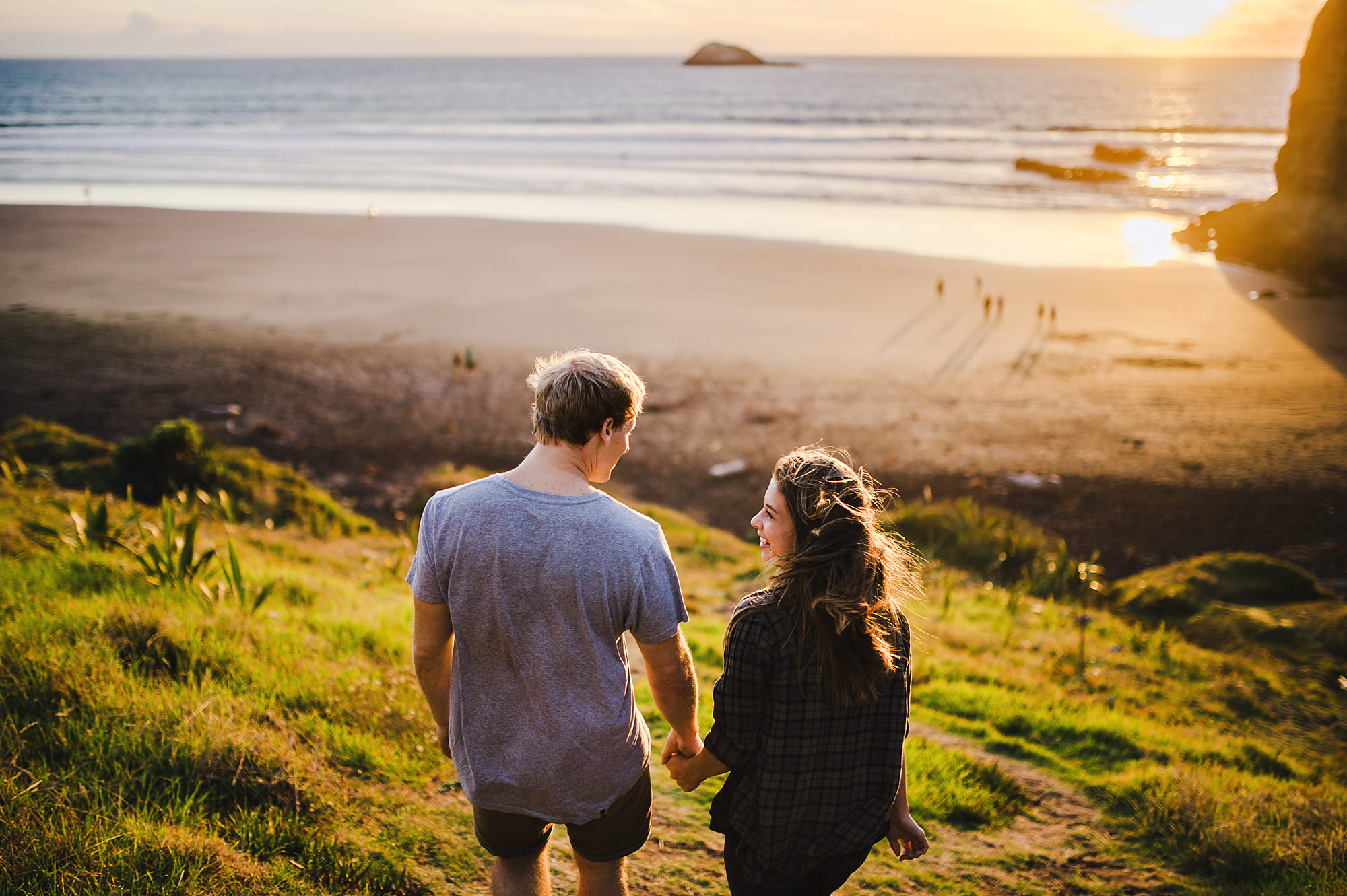 11 couple walking into sunset on beach muriwai.jpg