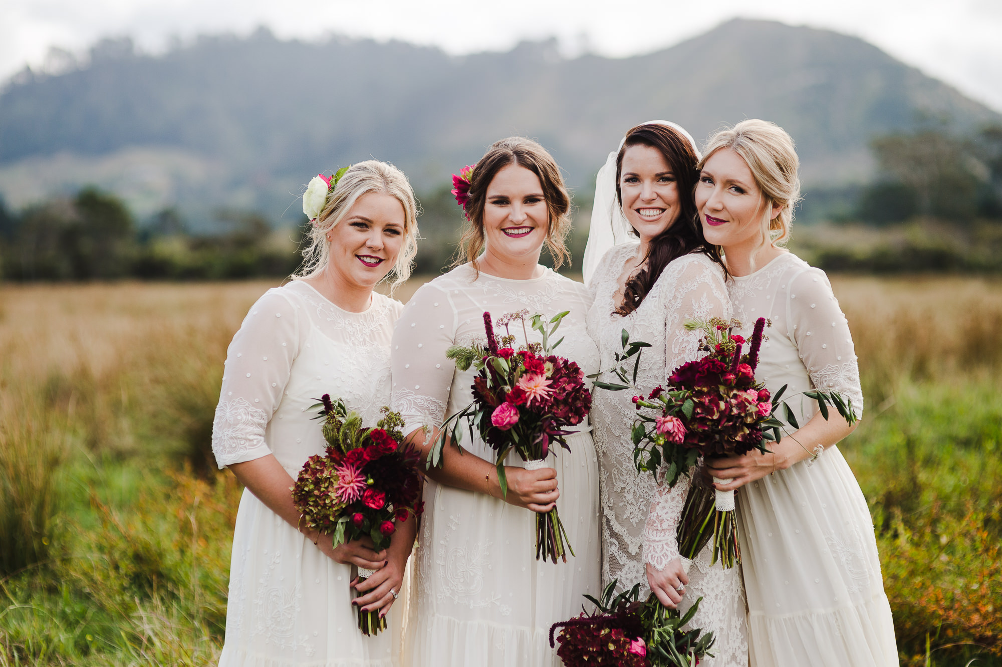 bridesmaids with flowers in field.jpg