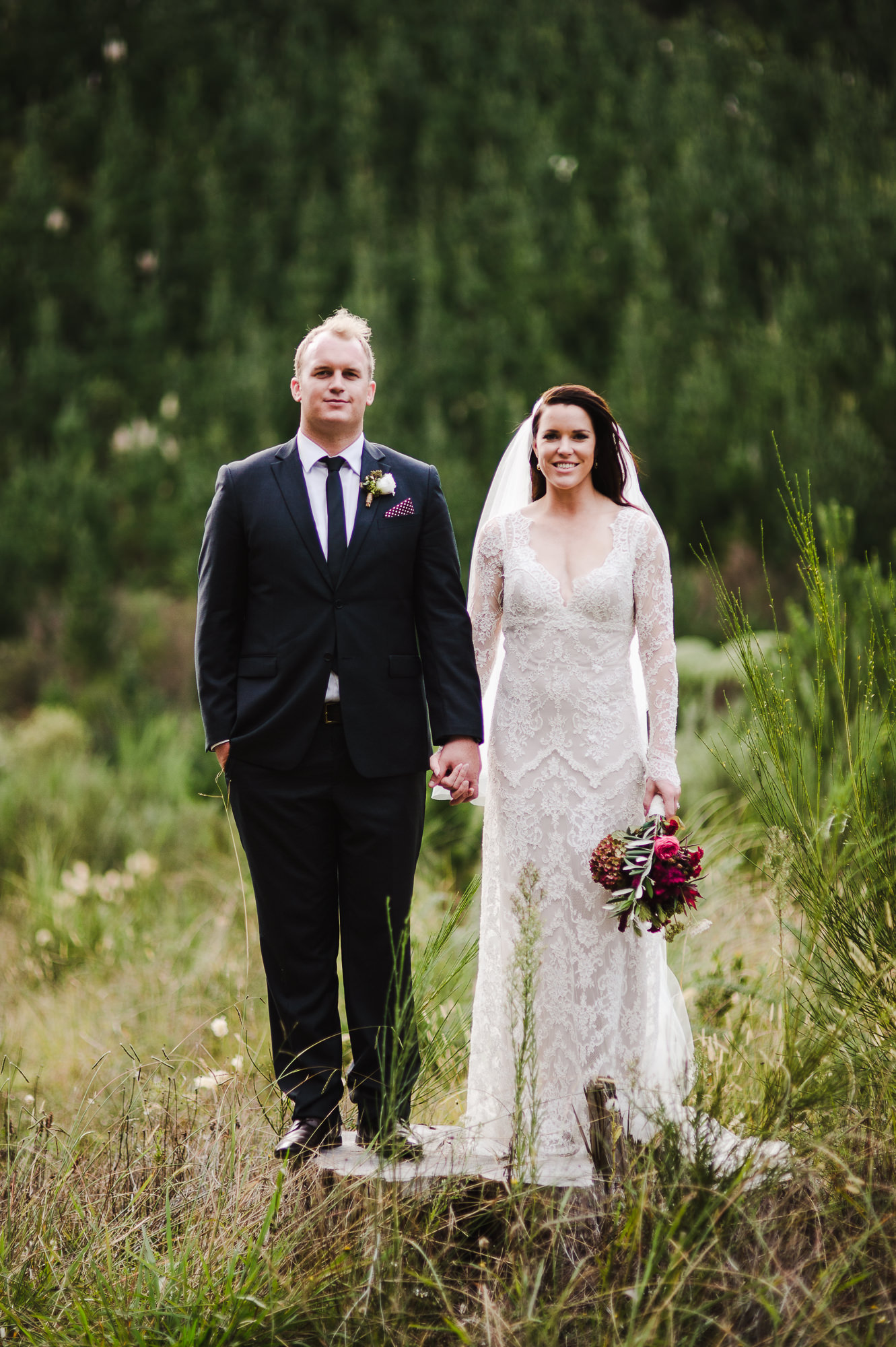 bride and groom standing on a tree stump.jpg