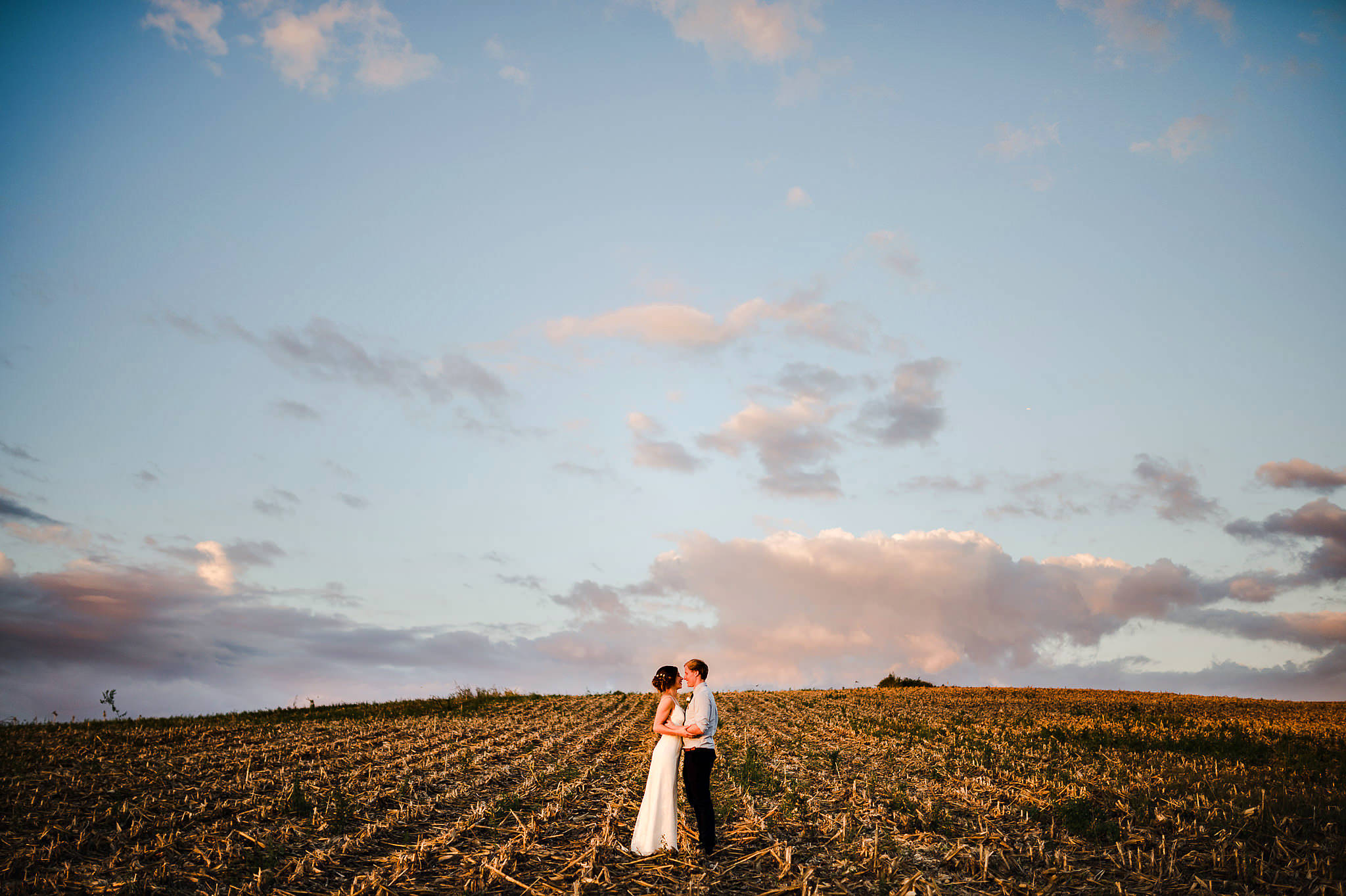 bride and groom in field at sunset auckland wedding photography.jpg