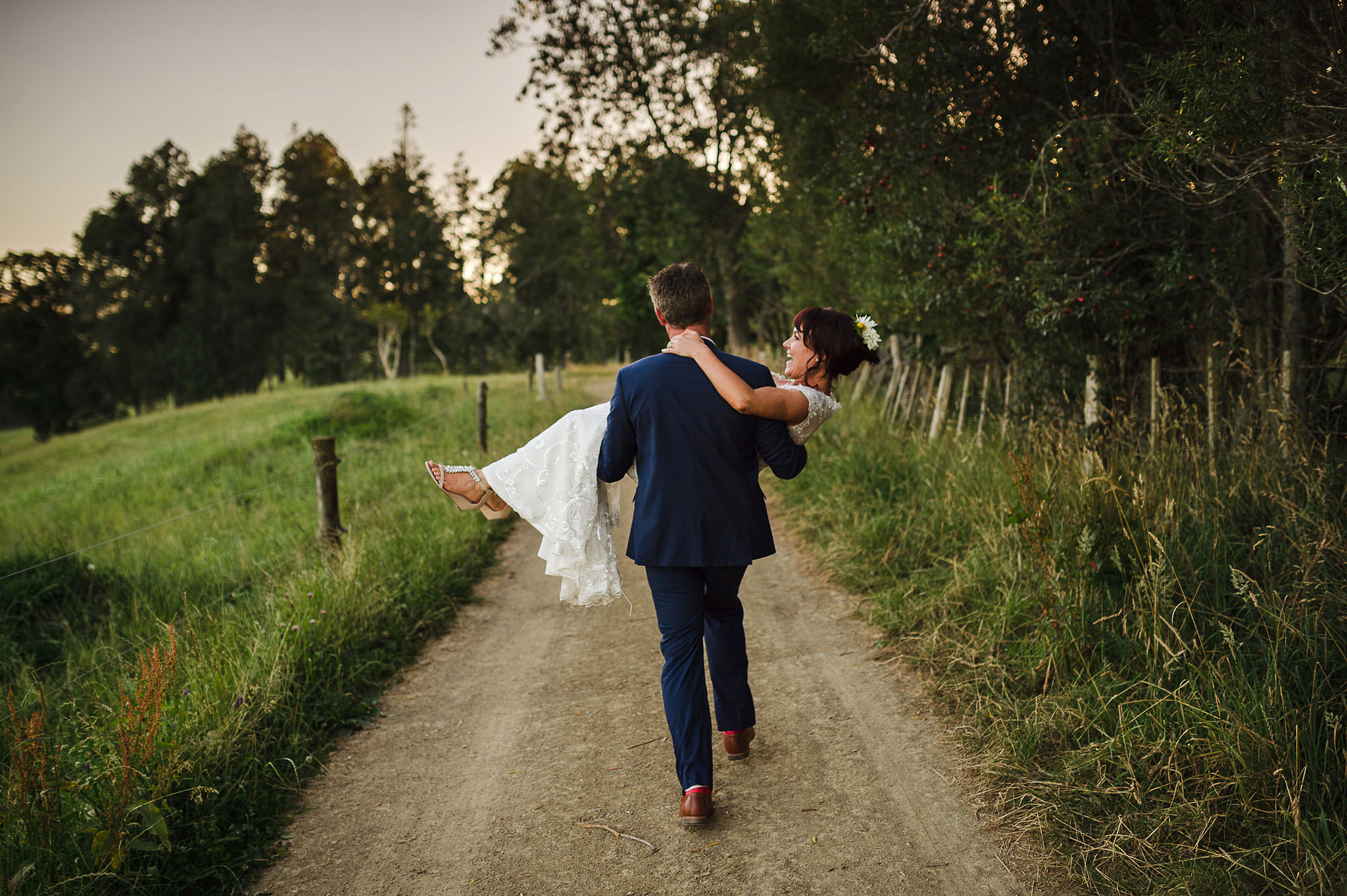 37 raglan wedding spontaneous moment groom carrying bride through countryside.JPG