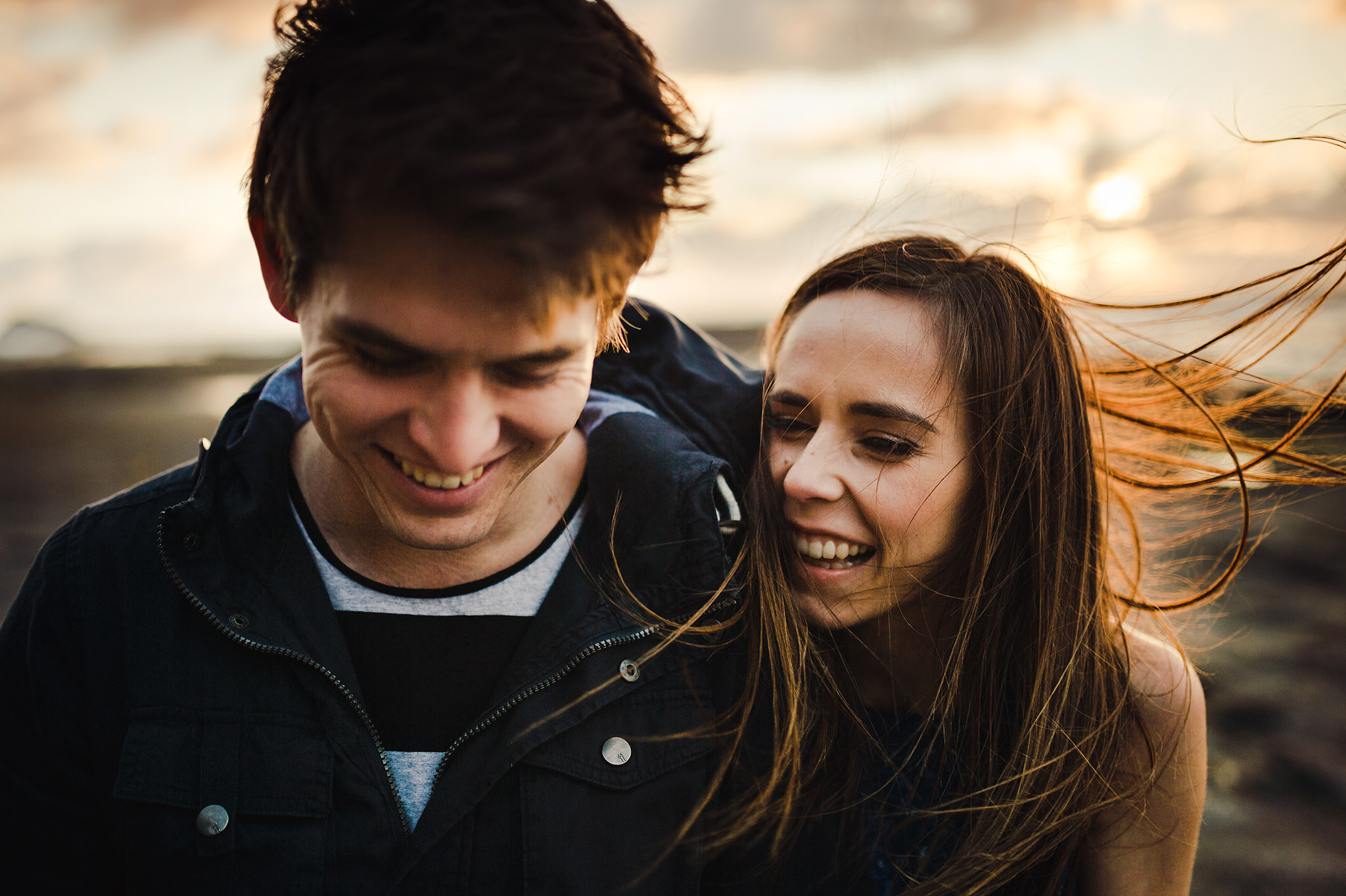 46 muriwai couple hair blowing in wind moment close up.JPG