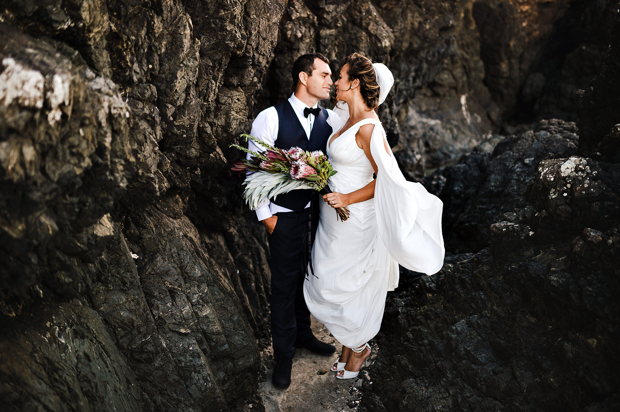 65 whananaki wedding bride and groom amongst rocks.JPG