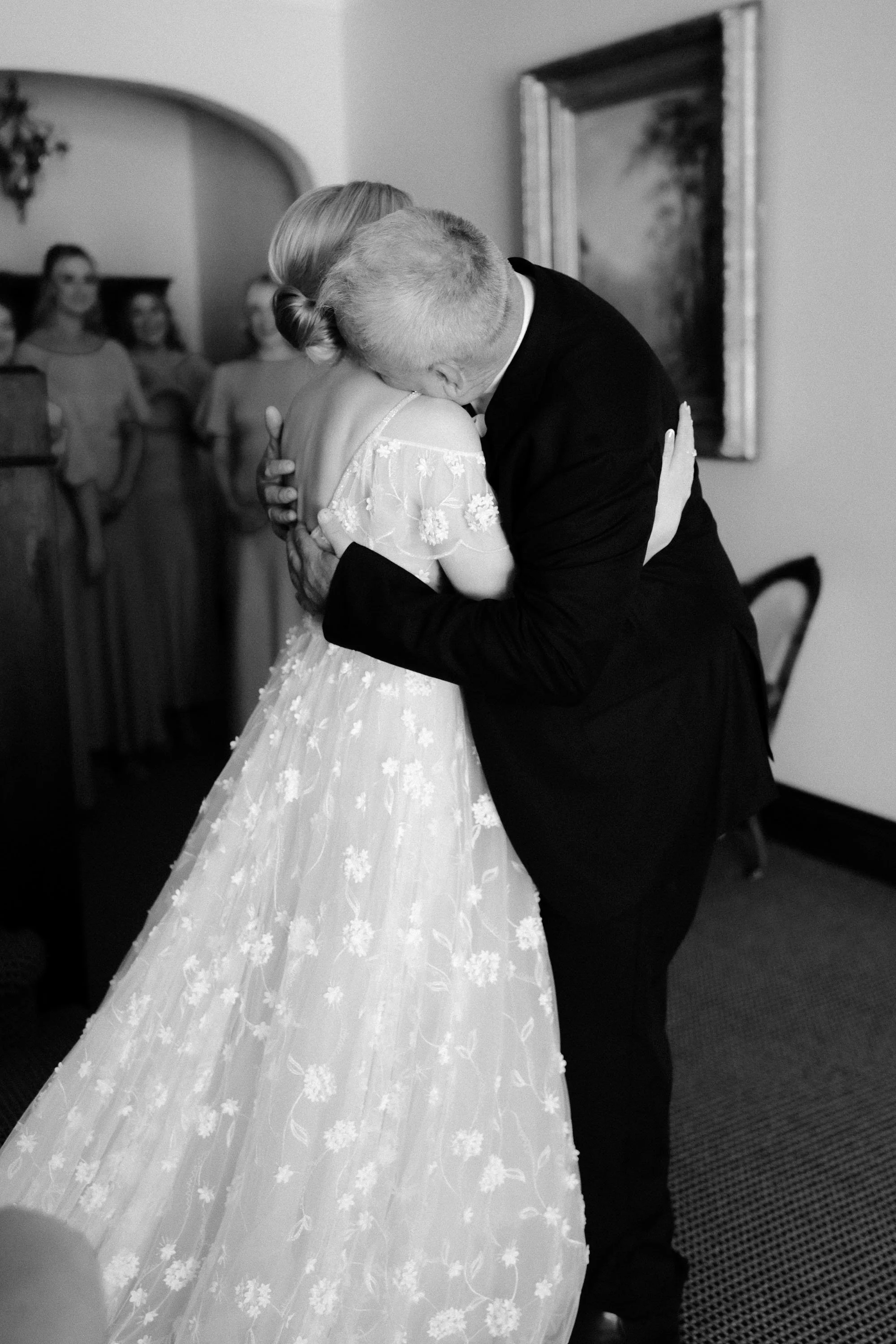 father hugging daughter during first look in black and white