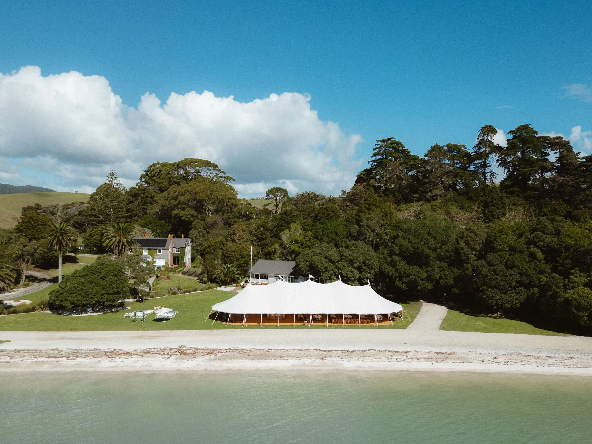 Drone shot of wedding marquee setup at The McCallum Residence, with private beach in foreground