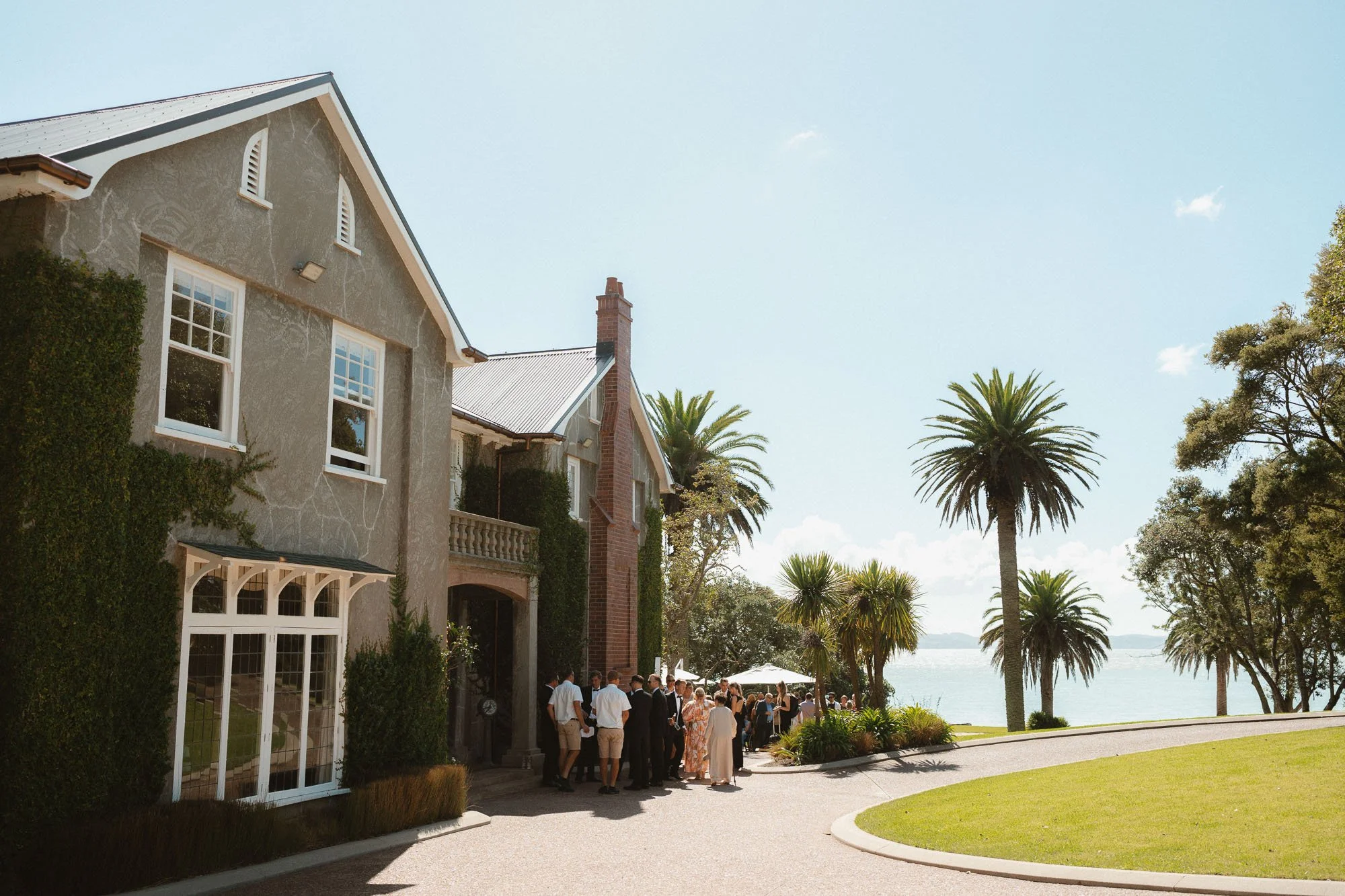 Exterior shot of guests arriving and mingling outside The McCallum Residence