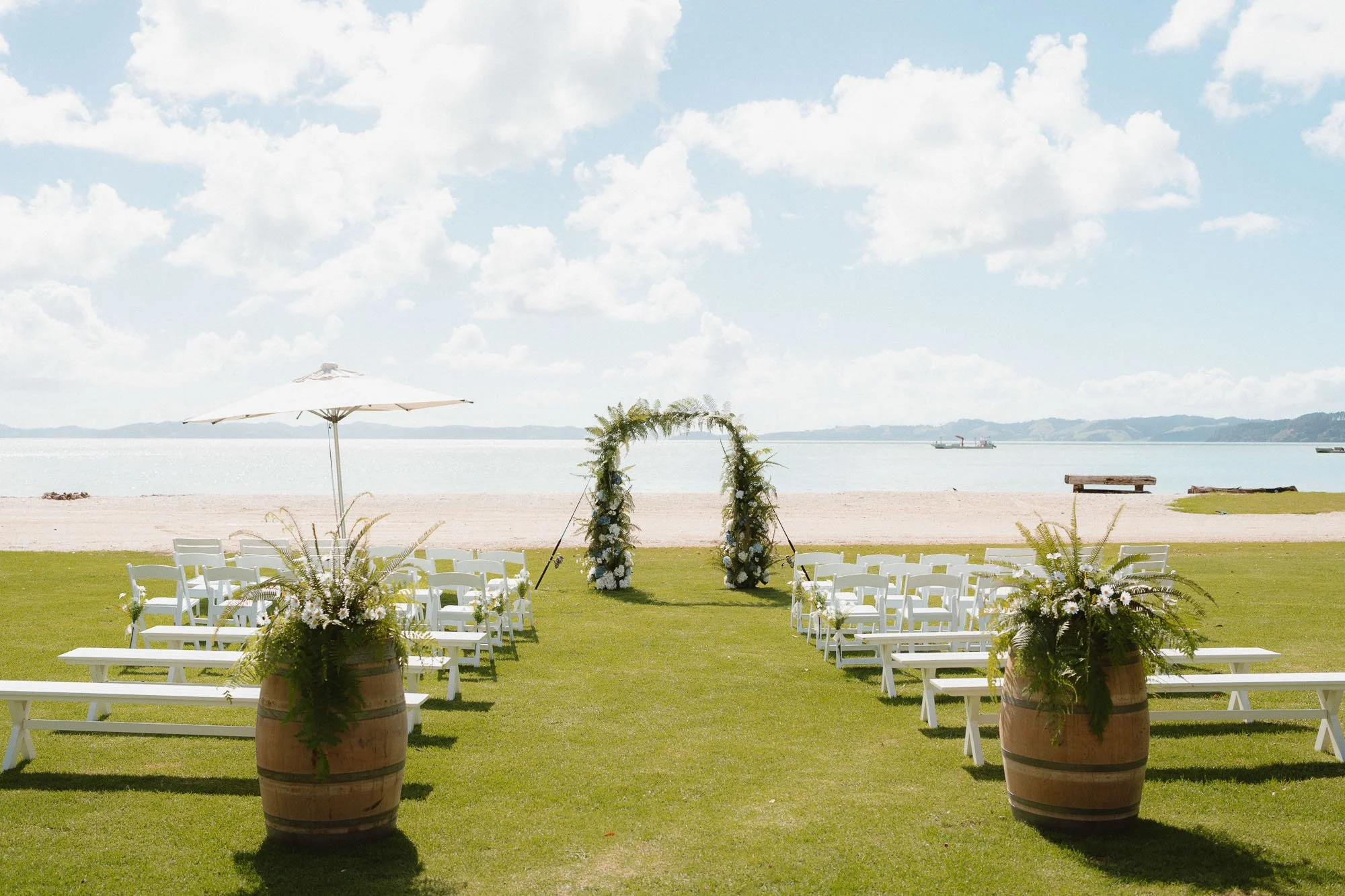 Ceremony setup, summer wedding at The McCallum Residence looking out to the beach, white chairs, fish rod styled arch