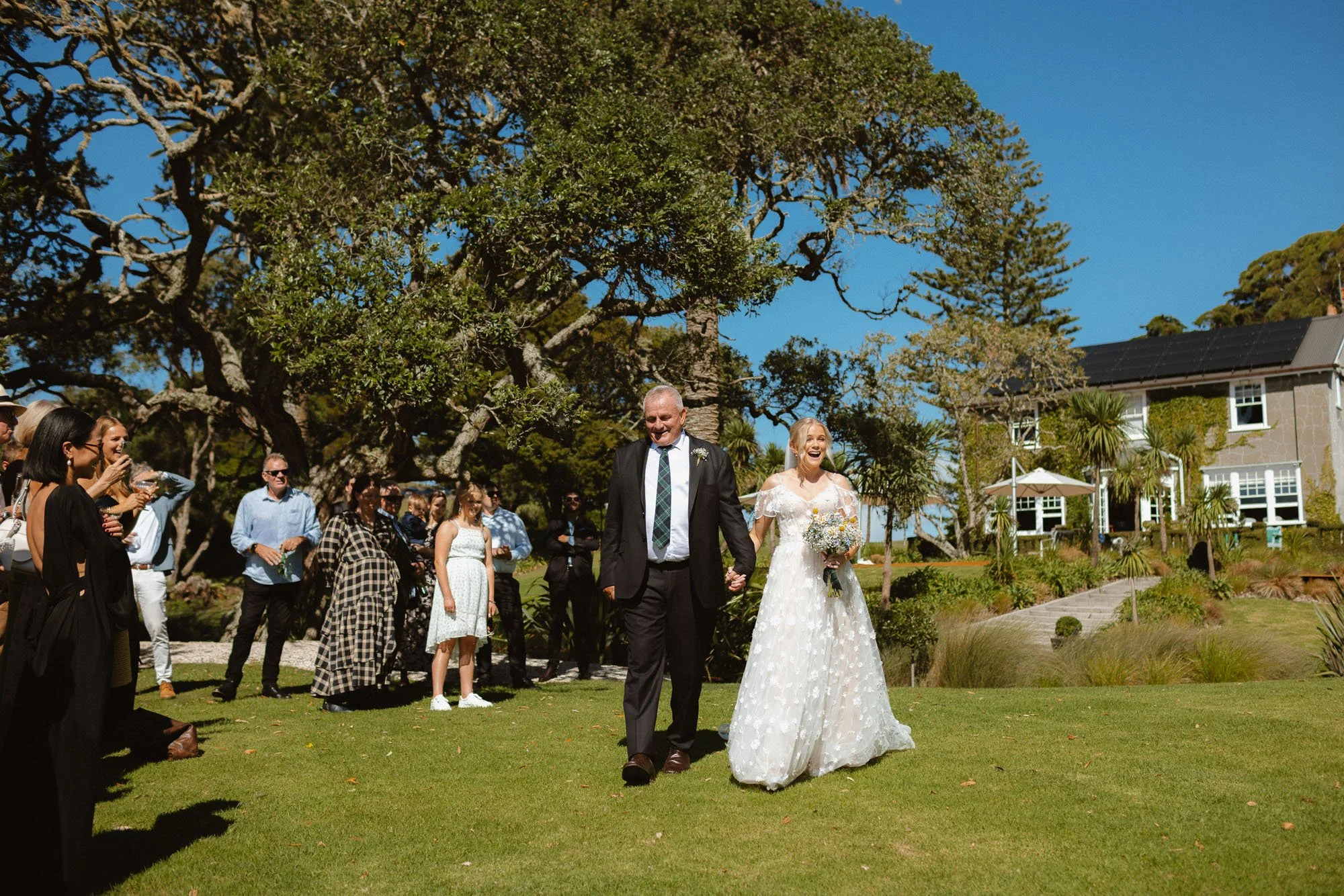 Bride walking down aisle on grass at The McCallum Residence
