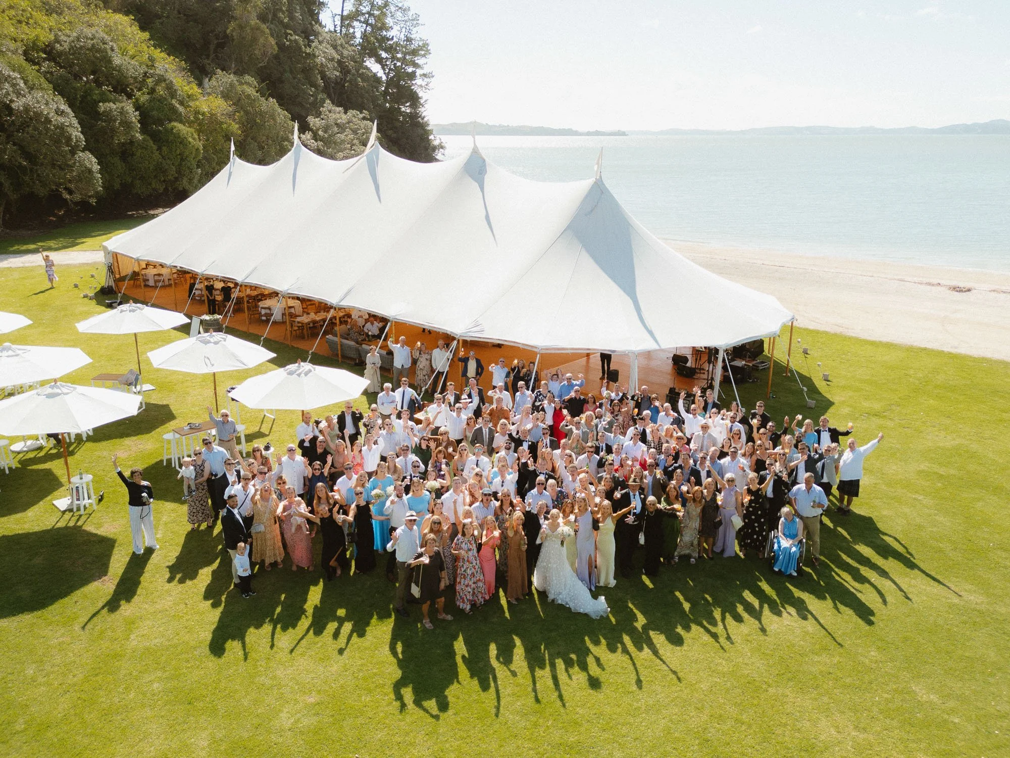 Group photo at The McCallum Residence with marquee and beach in background