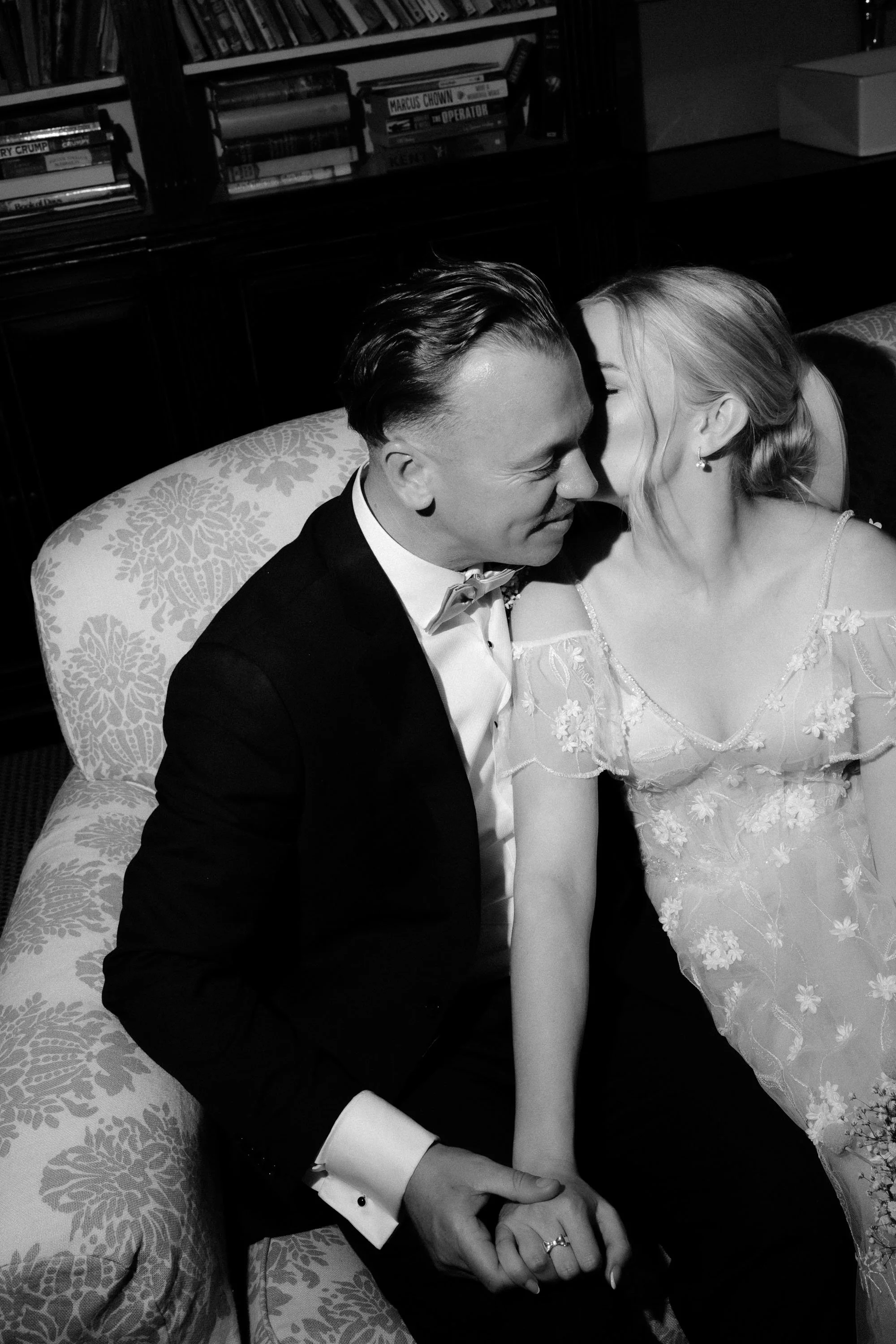 Direct flash photography of bride and groom having interior moment together inside library