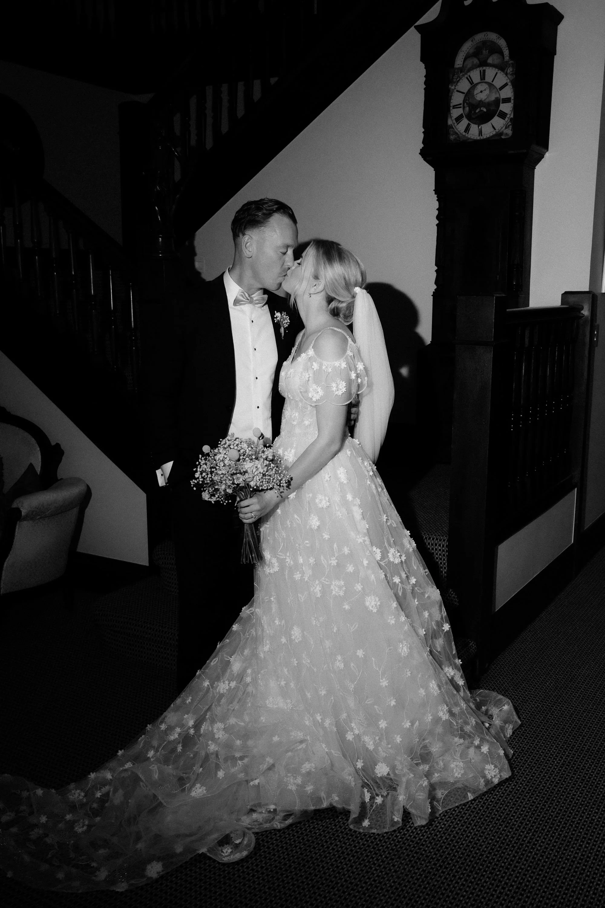 Direct flash photo of bride and groom kissing in stairwell inside The McCallum Residence