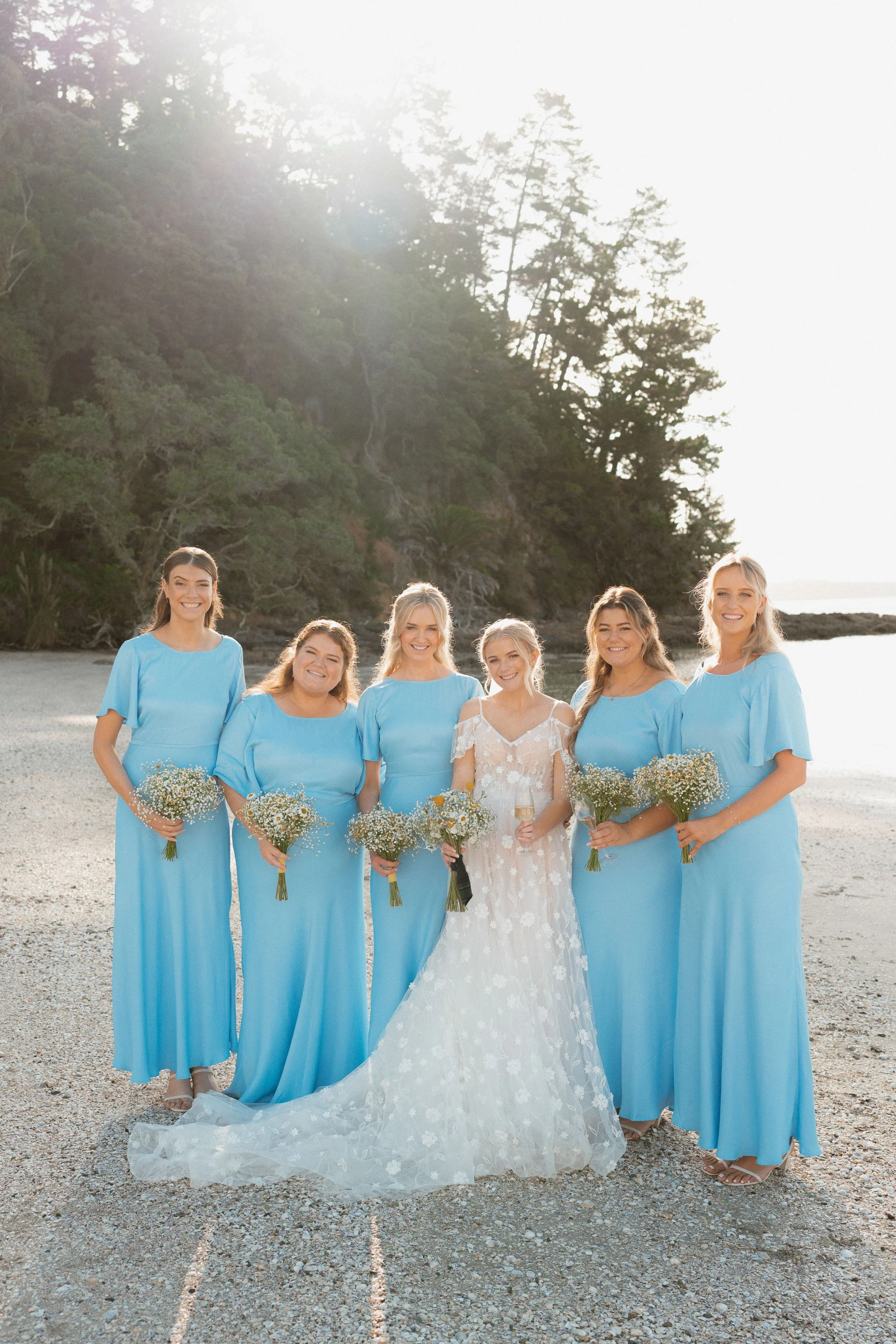 Portrait of bridesmaids backlit in sun on white shell beach at The McCallum Residence