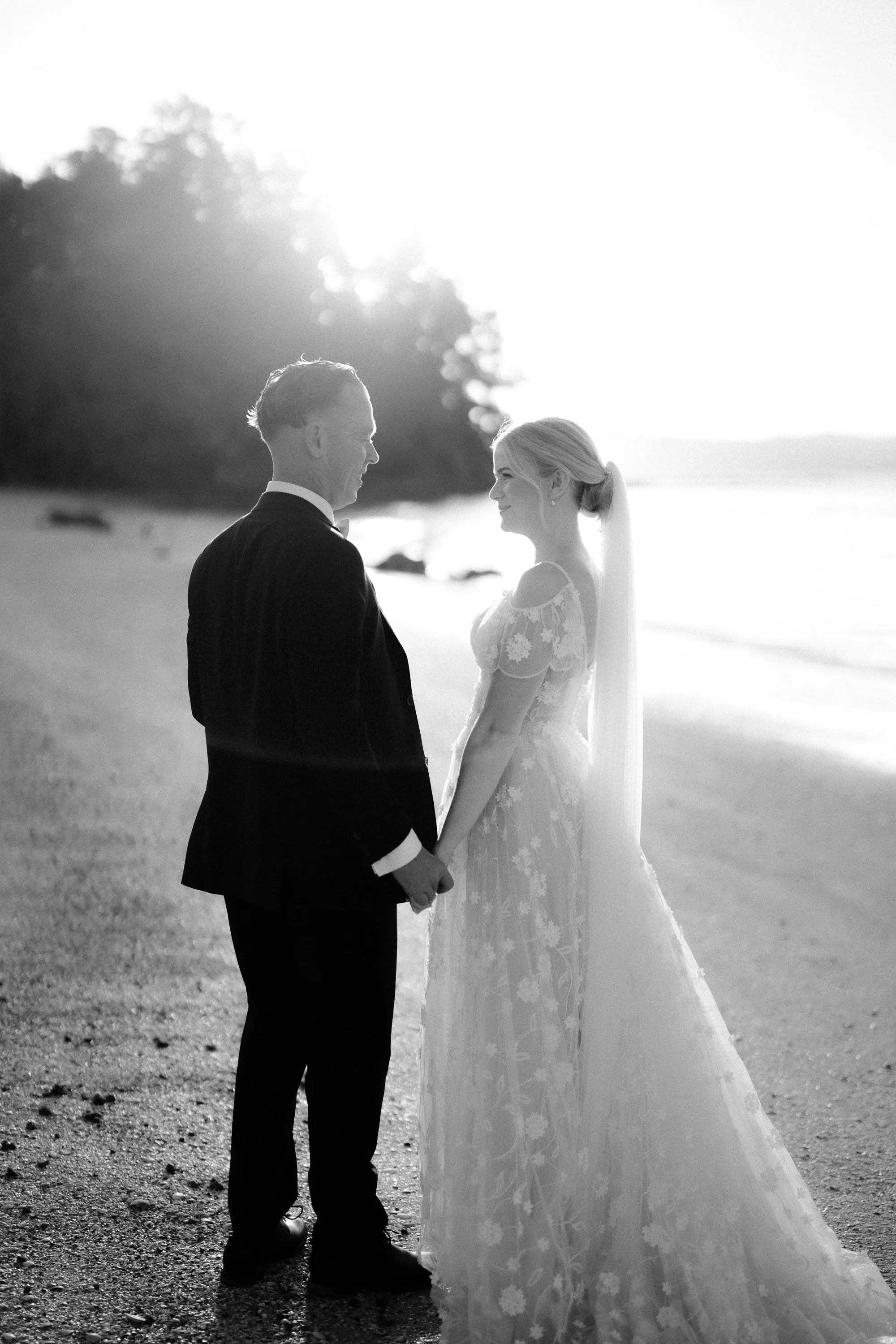 Black and white moment of wedding couple at sunset