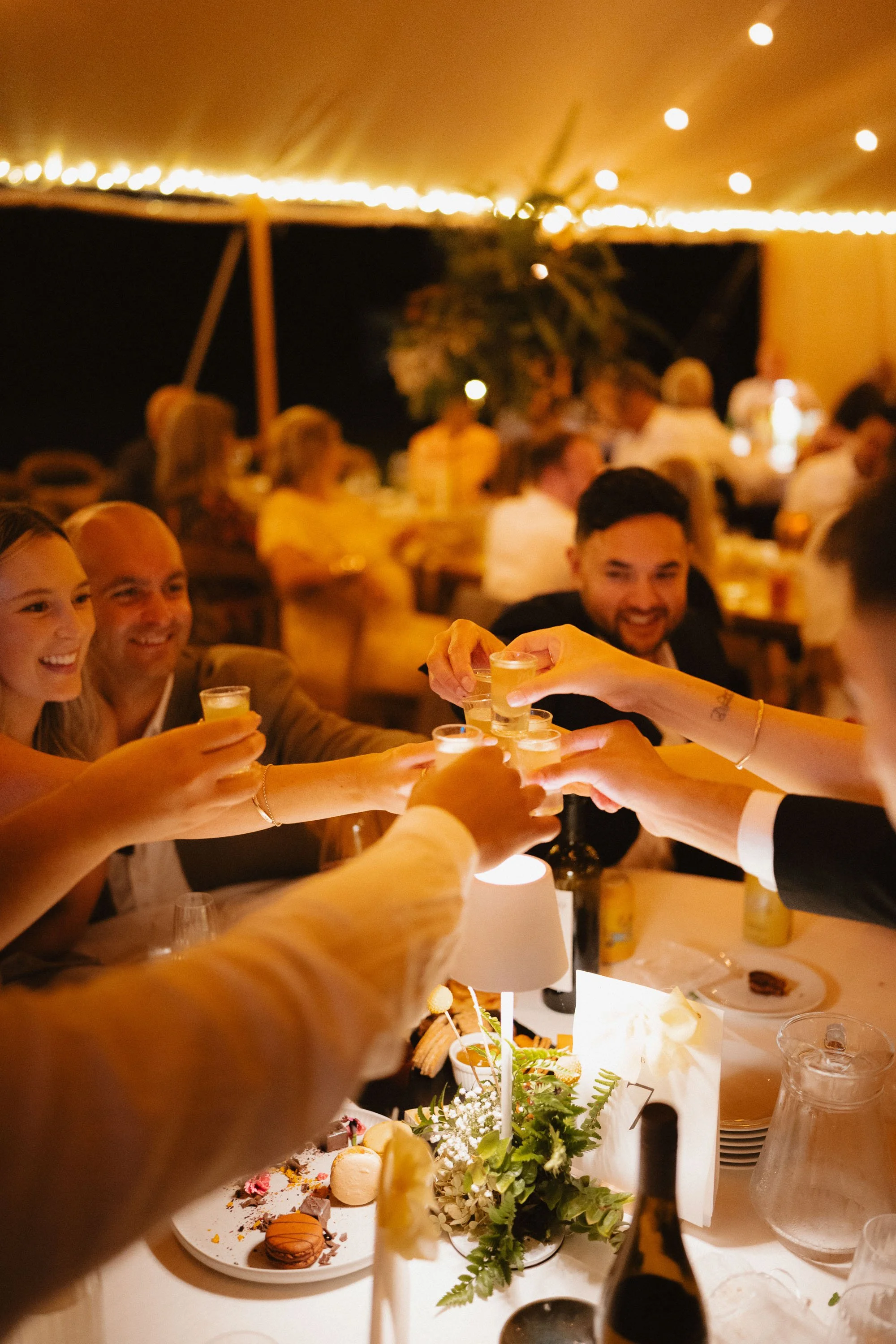 Close up of hands cheersing lemoncello shots