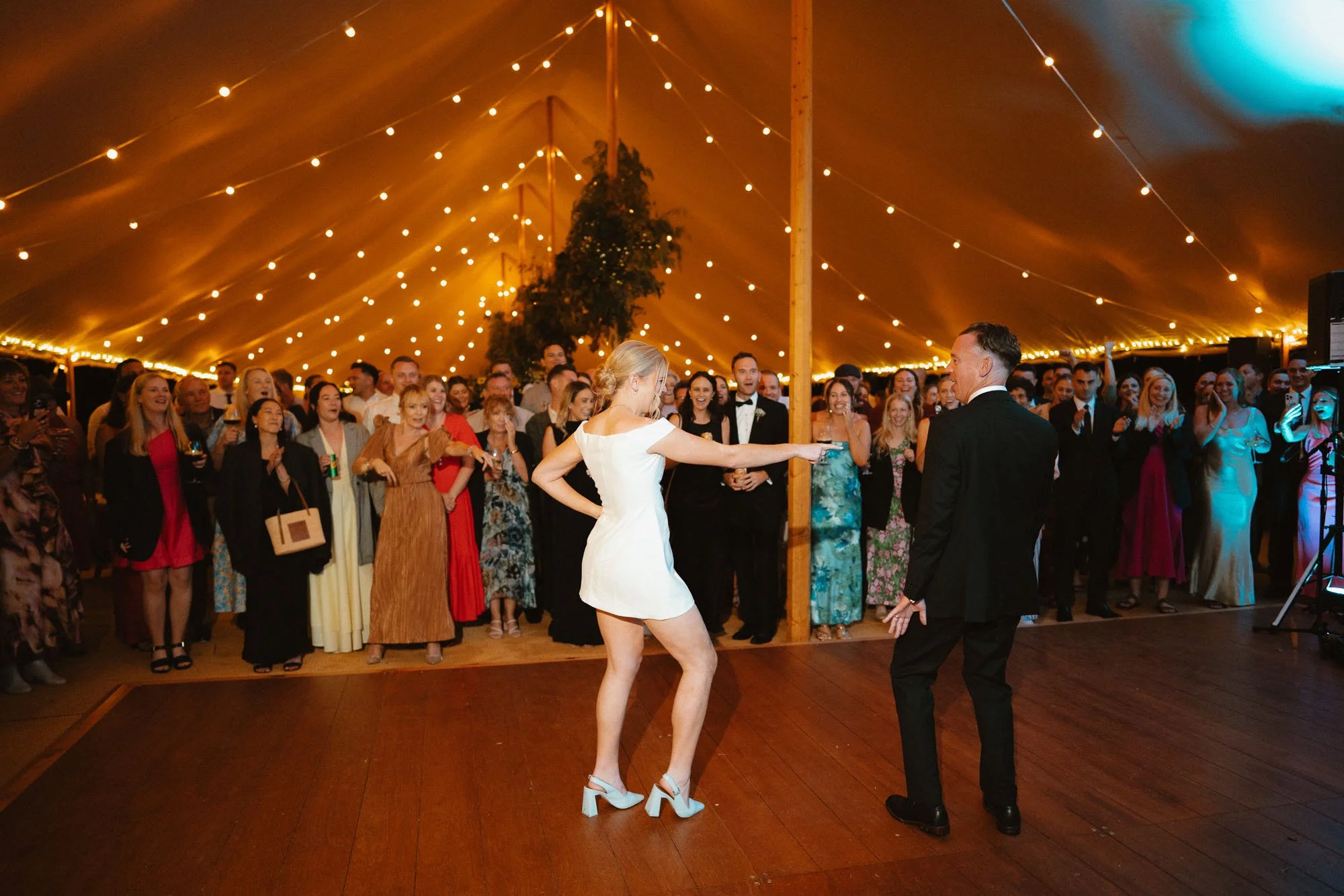 Bride and groom doing first dance on dancefloor of Flagship Events marquee with festoon lights