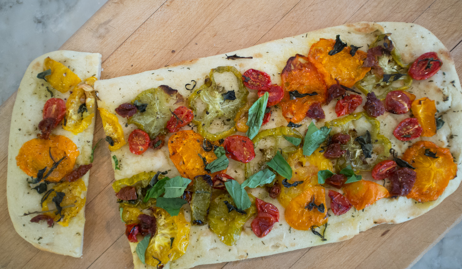 Tomatoes on warm bread with fresh basil and a drizzle of olive oil.