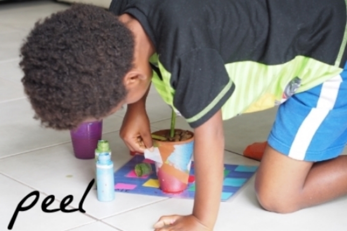 child paints flower pot 