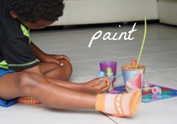 child paints flower pot 