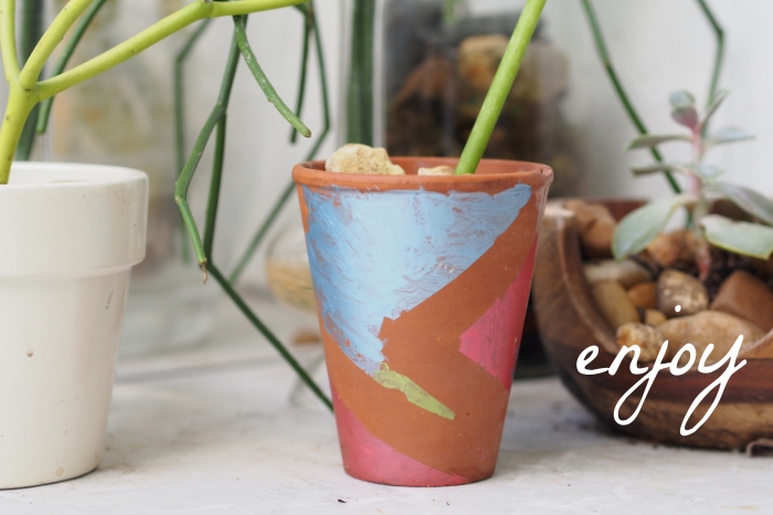 child paints flower pot